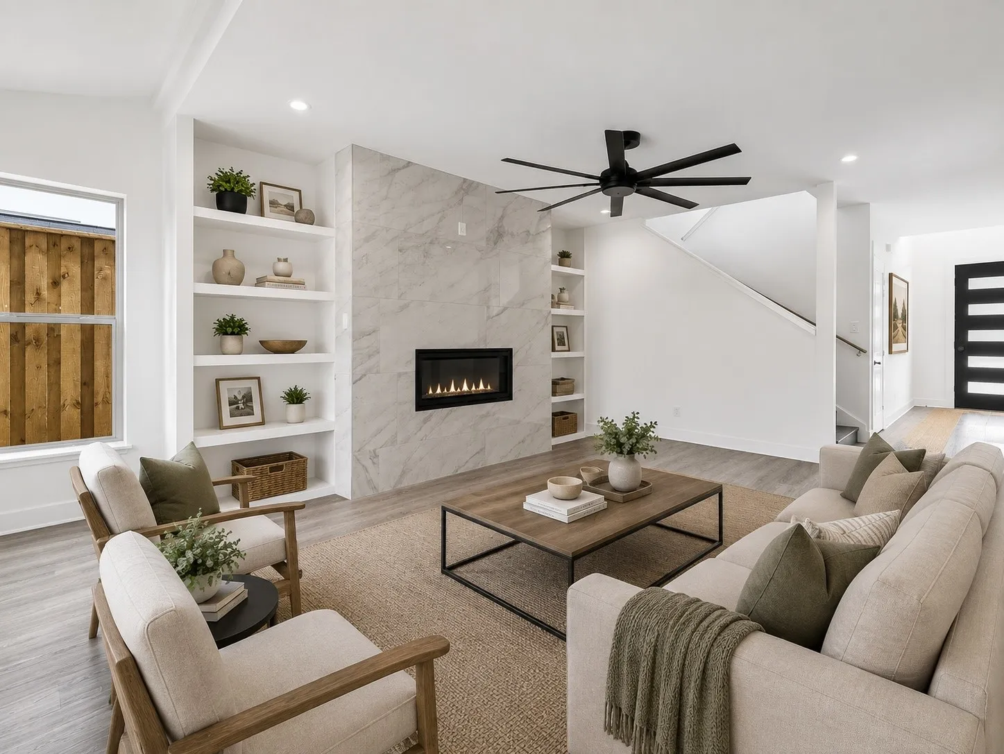 Recessed lighting illuminates the living area, featuring built-in shelving, a modern