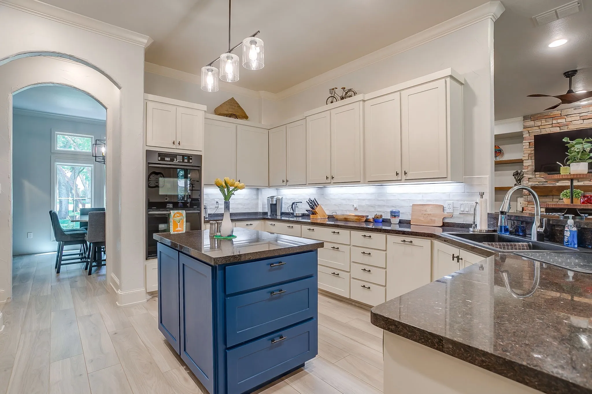 Double ovens, island with drawer microwave, wine fridge, gas range, sink overlooking outdoor living