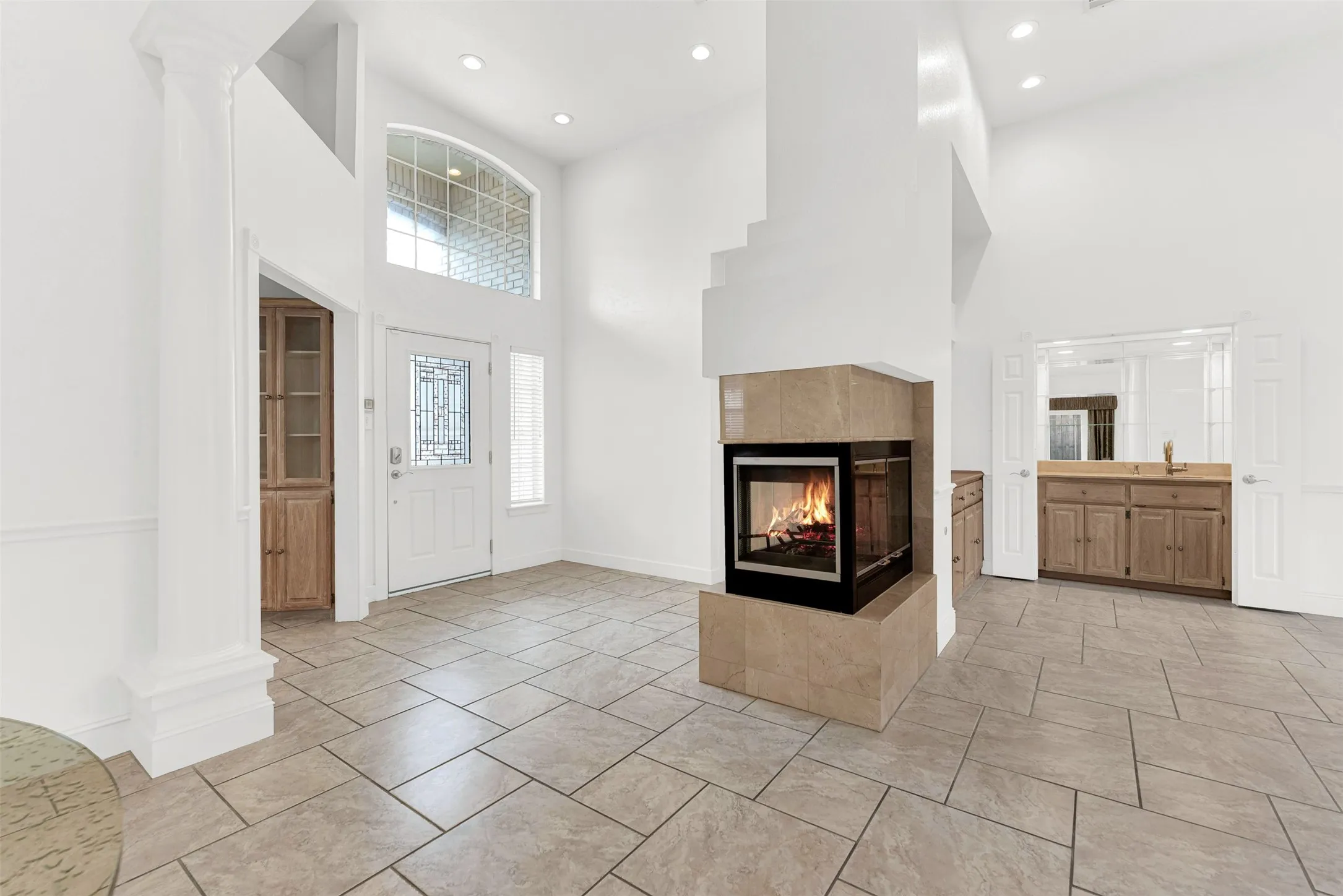 A high-set transom window above the main entrance bathes the entire two-story foyer in brilliant sunshine. It creates a cheerful, sophisticated first impression for friends arriving to celebrate a special occasion.