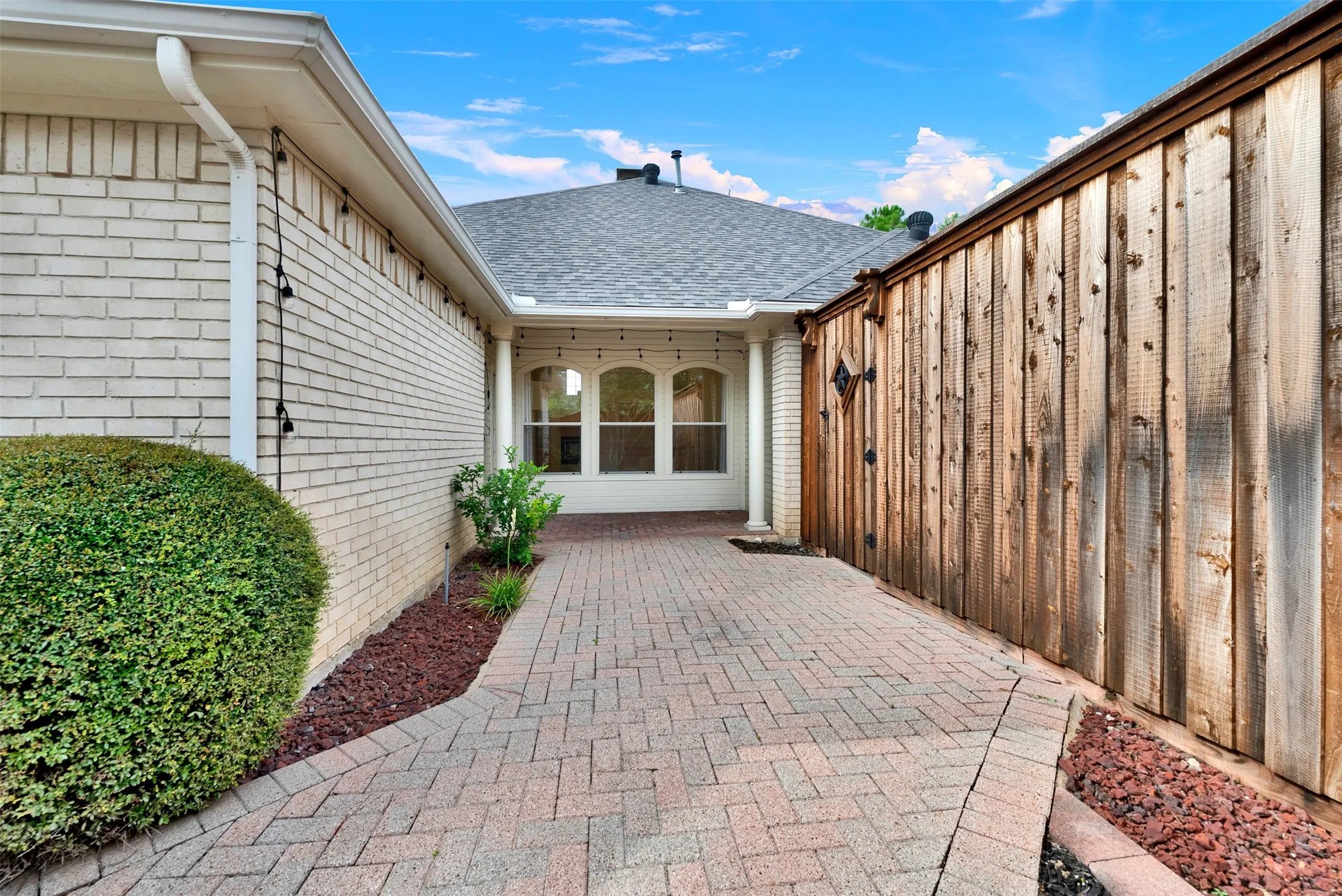 Arched windows tucked beneath the roofline add architectural depth while catching the changing colors of the sky. Plan an elegant dinner inside the dining room where the soft outdoor evening light sets a beautiful mood.