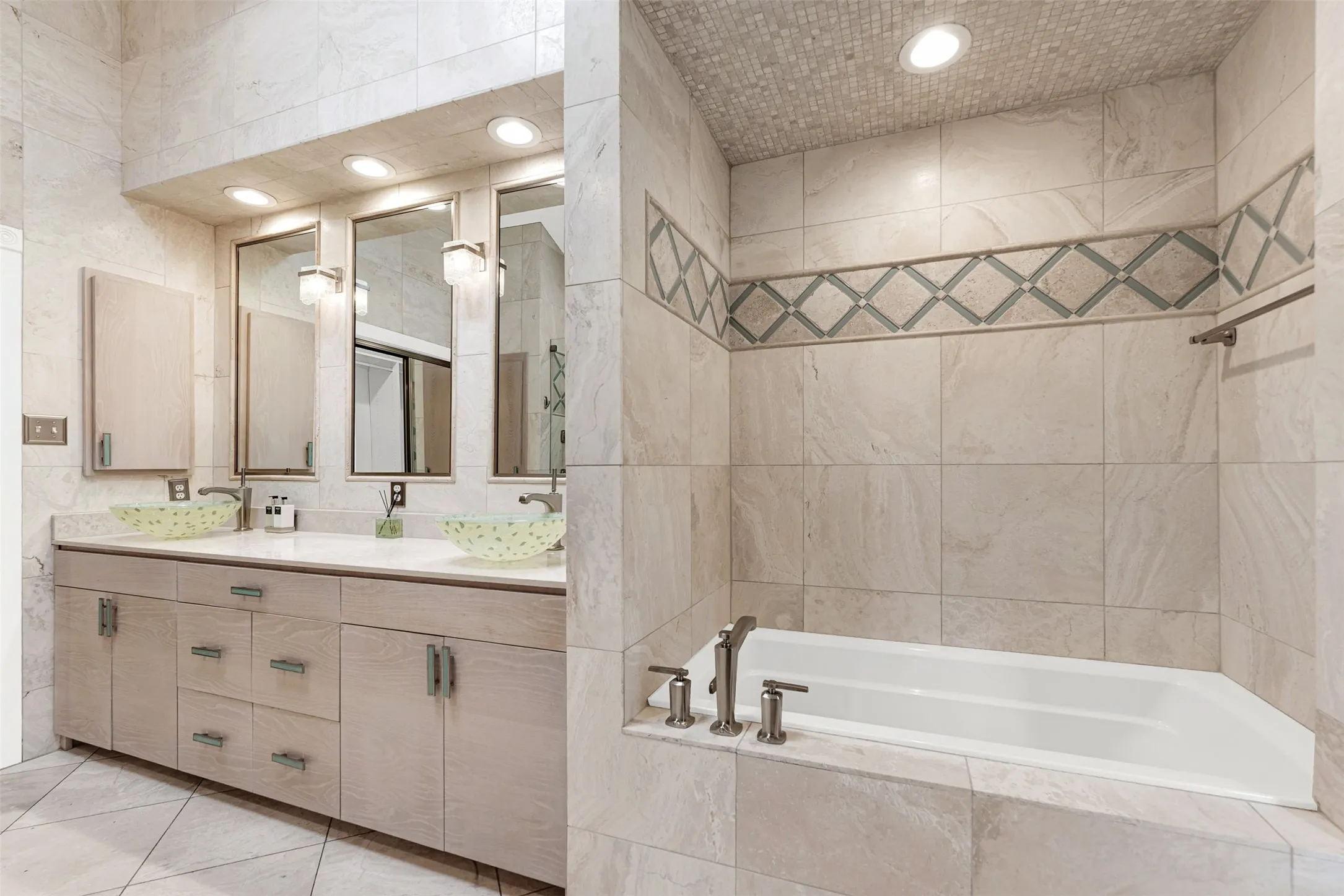 Light wood double vanities stretch beneath glowing, integrated mirrors and translucent vessel sinks. Enjoy an unhurried evening prep routine with plenty of elbow room to wind down comfortably.