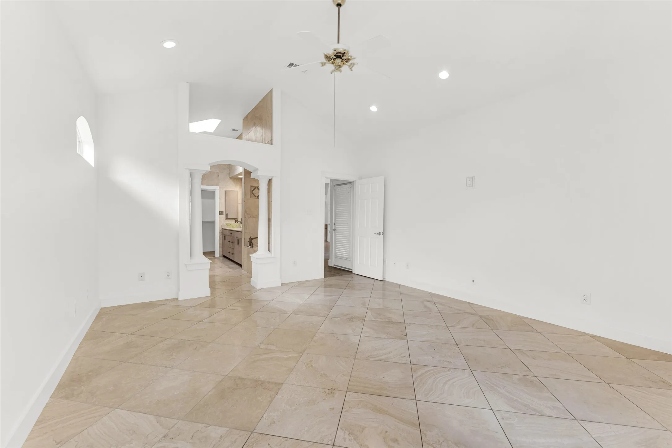 The soaring, multi-faceted vaulted ceiling elevates the room's acoustics and maximizes the sense of openness. Imagine ending your night in this serene, airy sanctuary, watching the shadows soften under the dimmable recessed lighting.