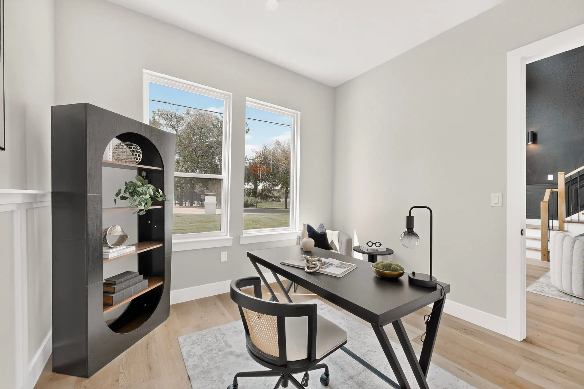 Dual windows with white trim, light-toned walls, and wood-finish flooring
