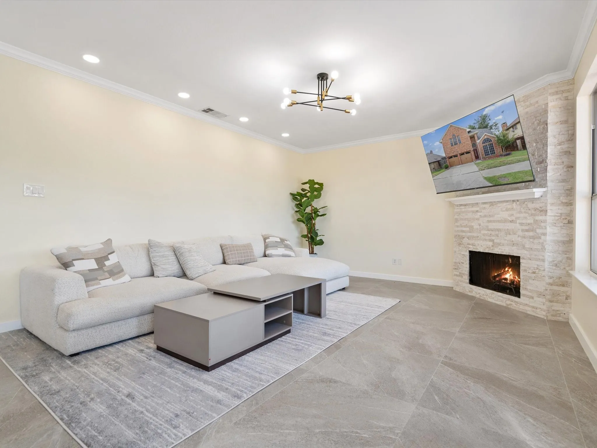 Living room with a fireplace, a chandelier, crown molding, and recessed lighting