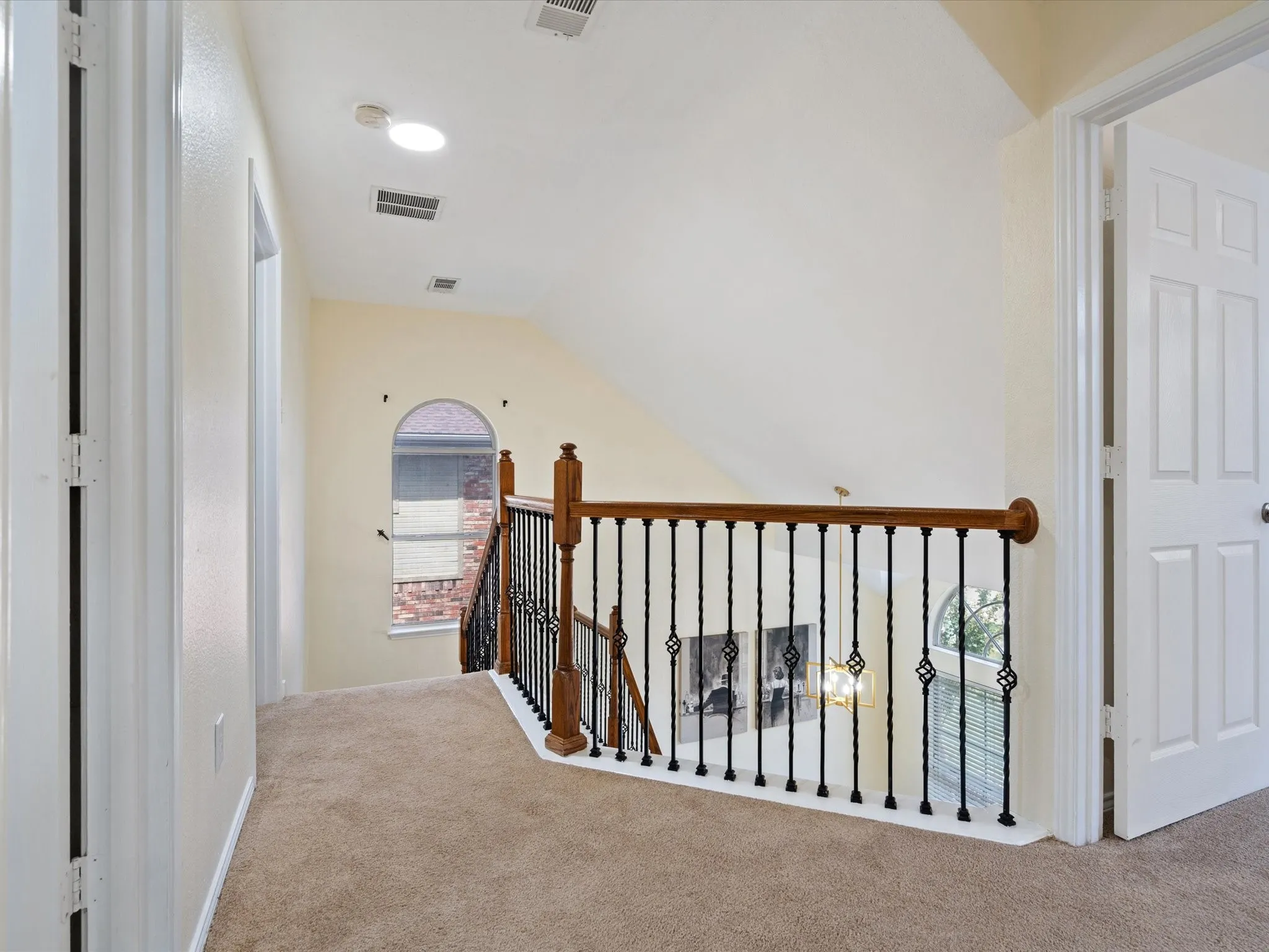 Corridor with carpet, vaulted ceiling, and an upstairs landing