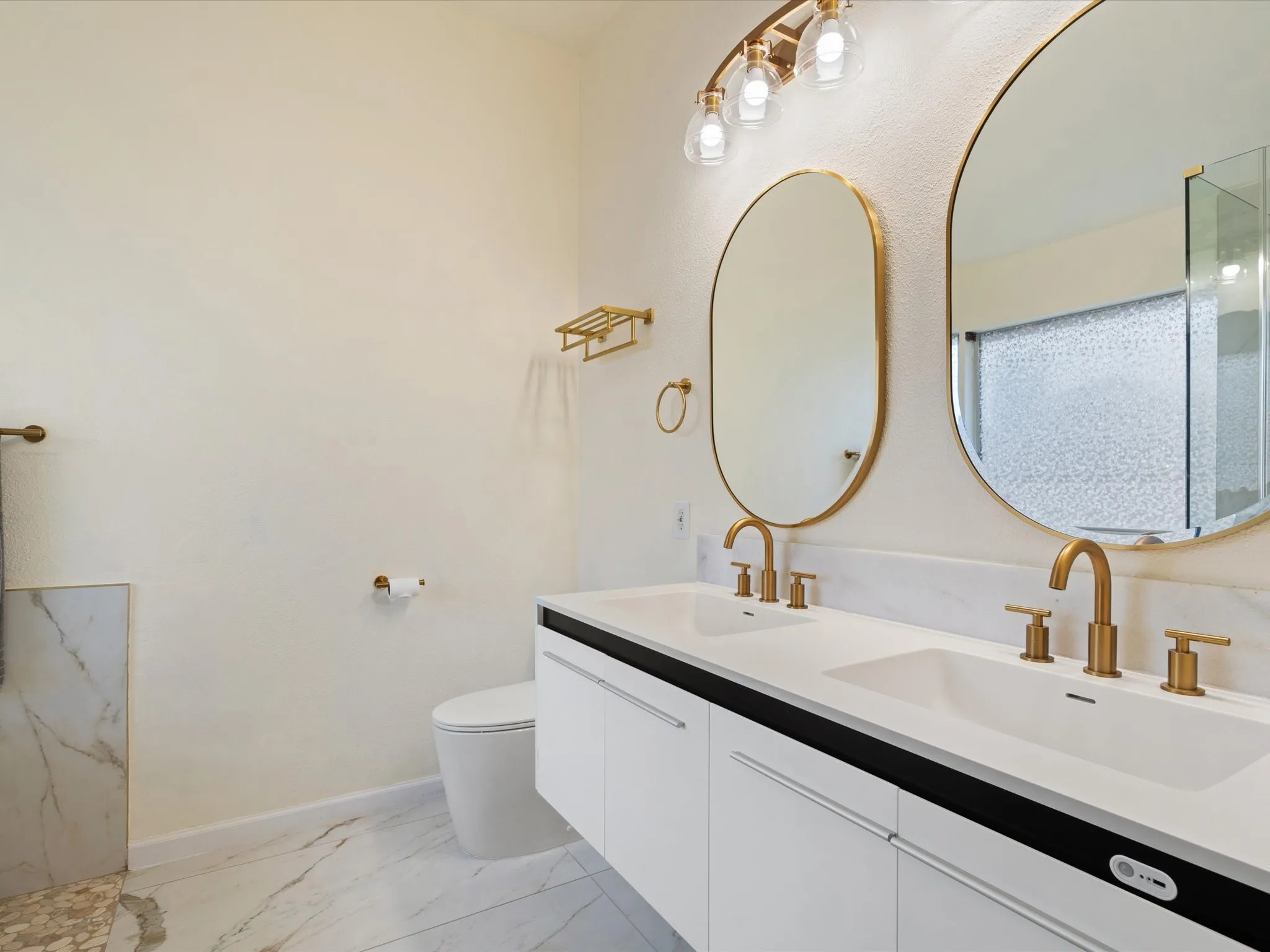 Full bath with double vanity and light marble finish flooring