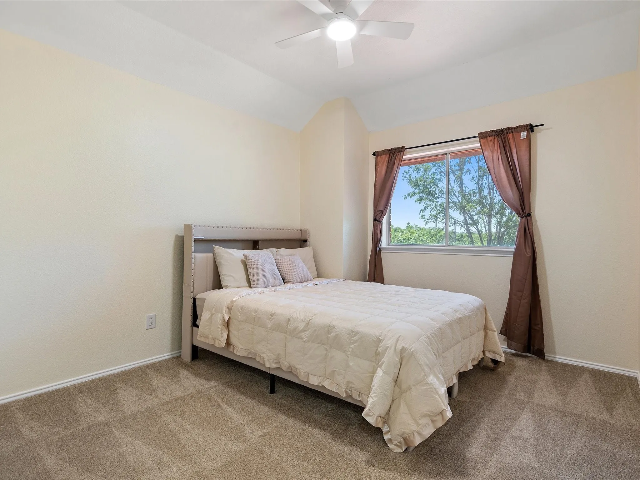 Bedroom with carpet, ceiling fan, and vaulted ceiling