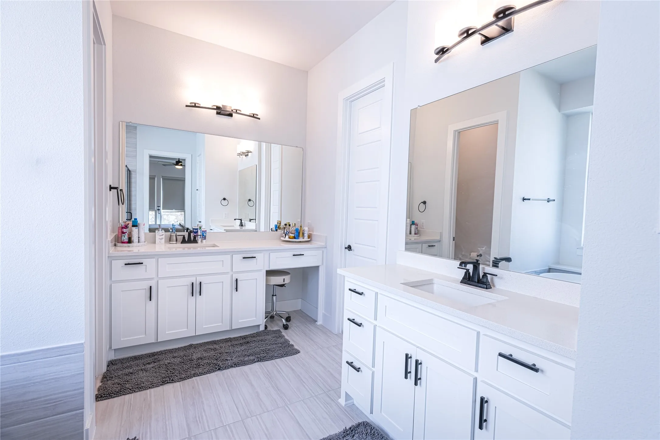 Dual vanity sinks with white cabinetry, quartz countertops, and matte black fixtures