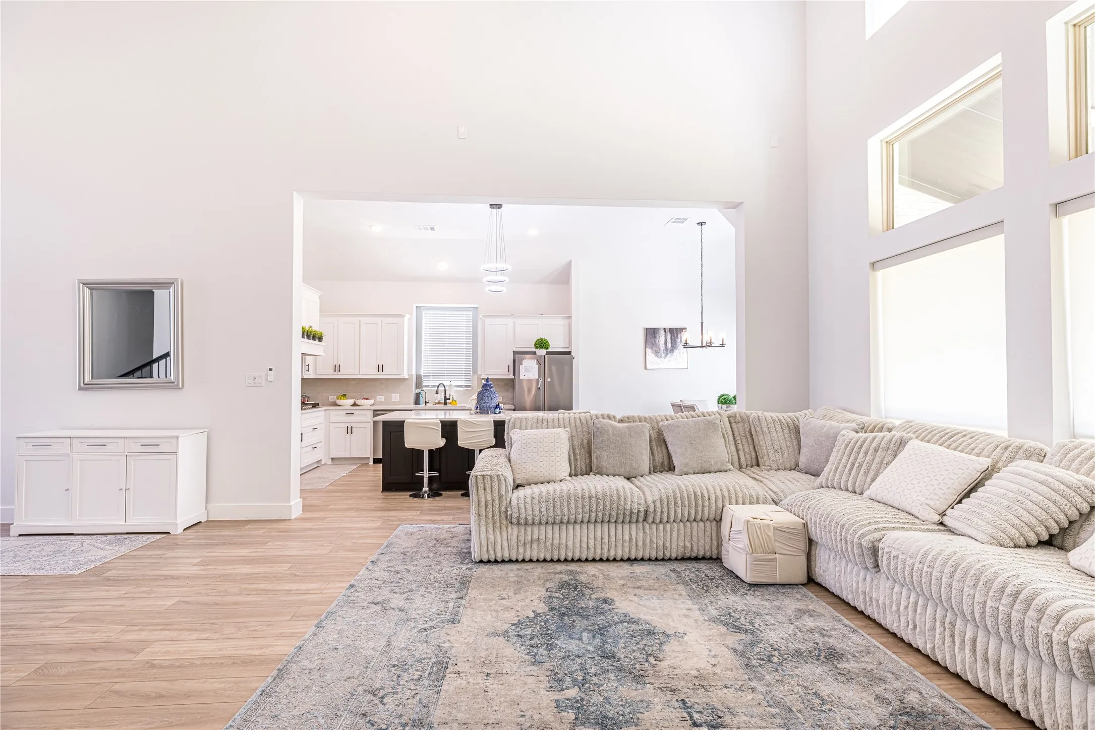 Double-height ceilings complement the light wood-finish flooring and expansive windows
