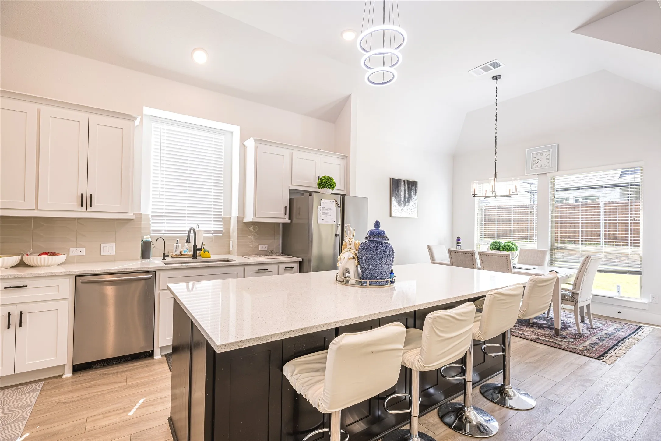 Modern kitchen featuring a large island with a light-colored countertop and dark base cabinetry