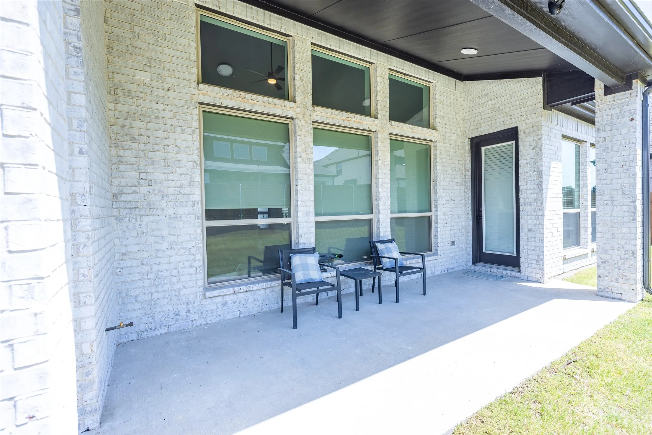 Covered patio featuring a concrete surface and light-colored brick exterior