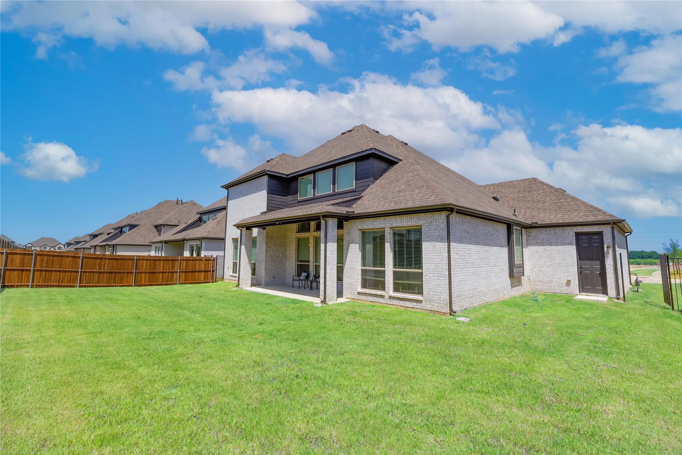 Expansive green lawn with a full privacy fence