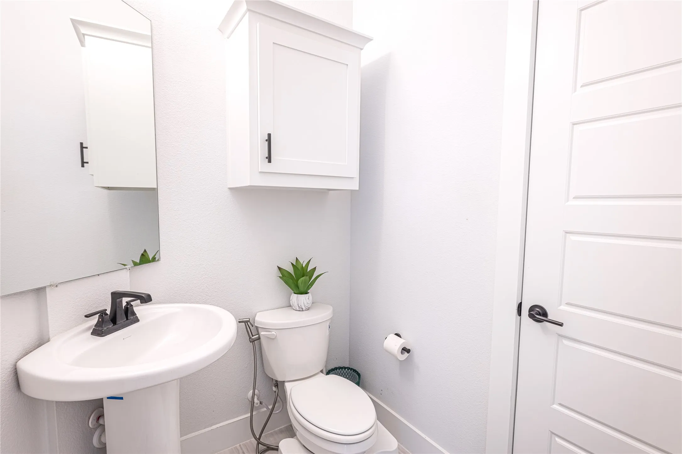 Pedestal sink with a matte black faucet