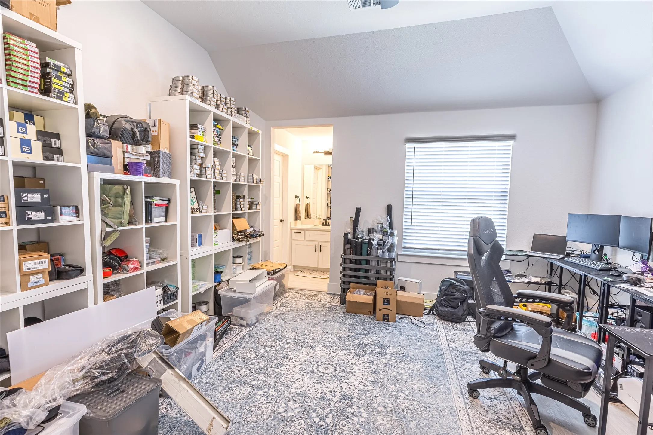 Spacious room featuring vaulted ceilings, a window with blinds, and light-toned walls