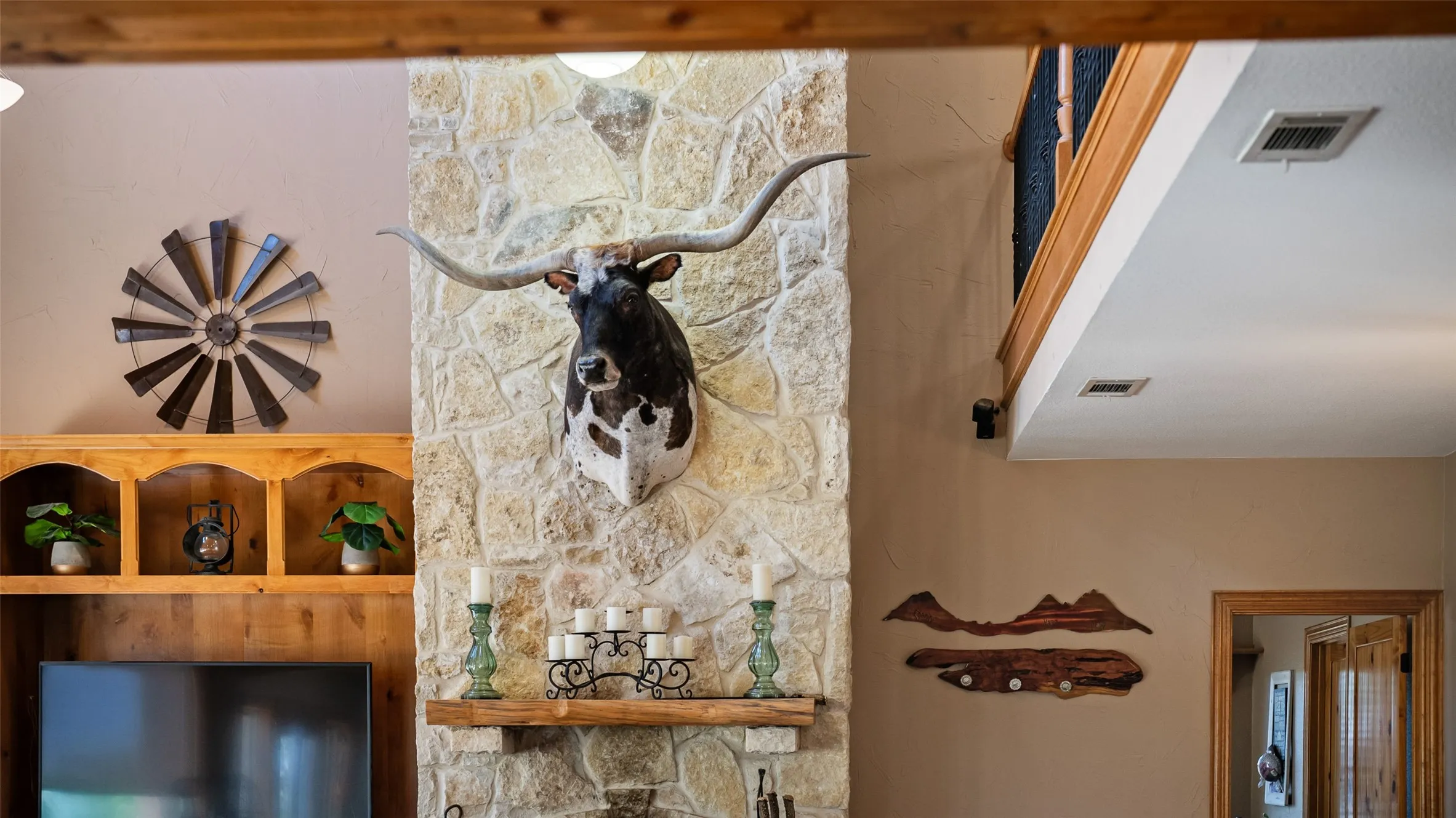 Stone-clad fireplace featuring a rustic wood mantel