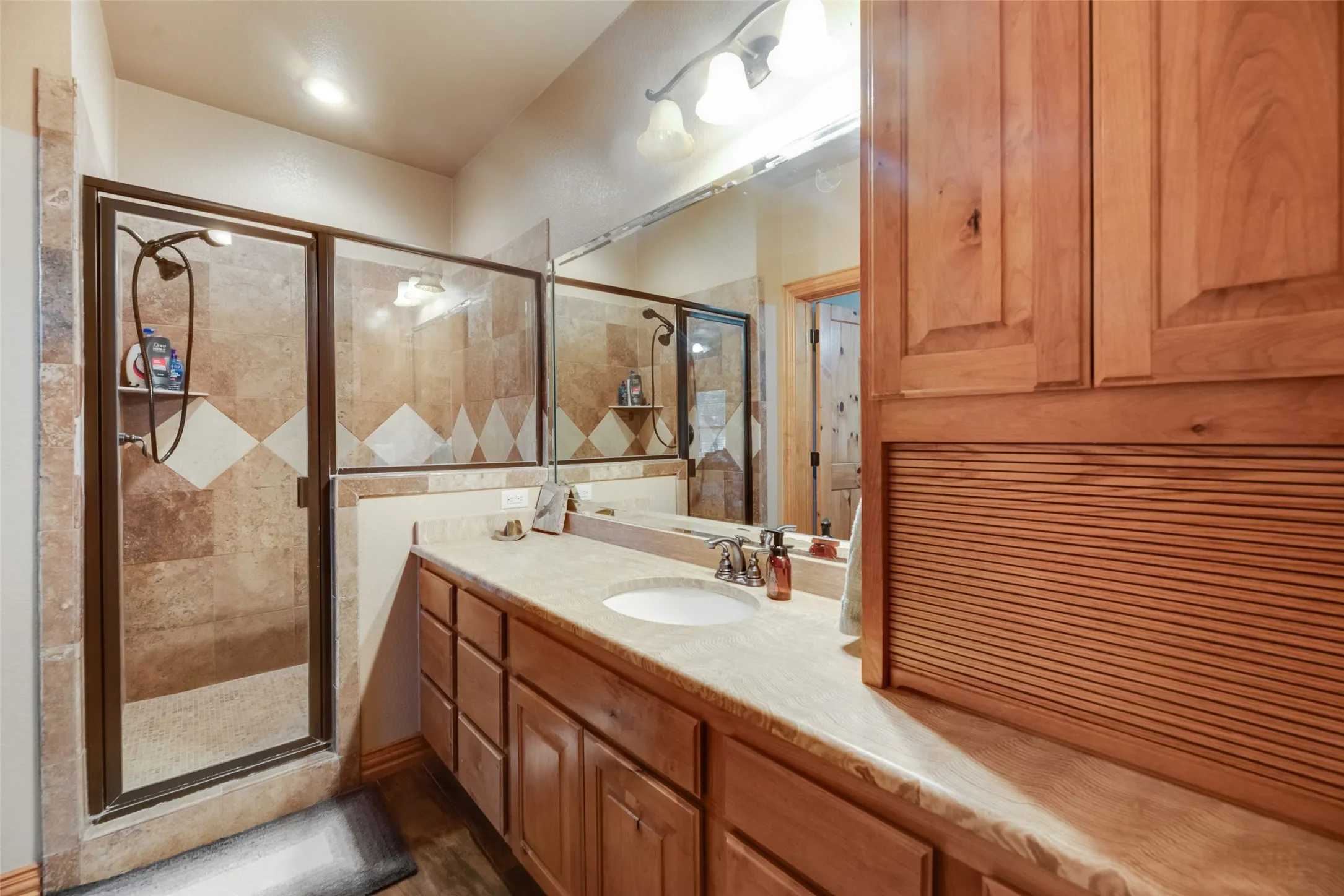 Walk-in shower featuring a tile surround with decorative diamond accents