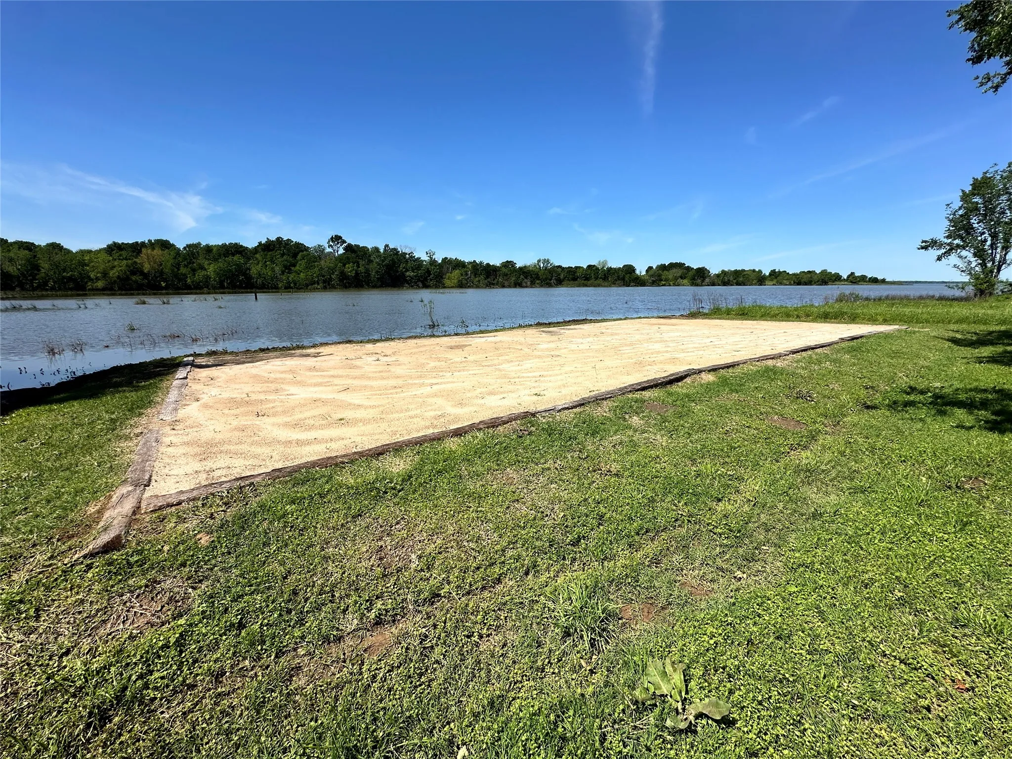 Lakeside community amenity area including a sand volleyball court and waterfront park.