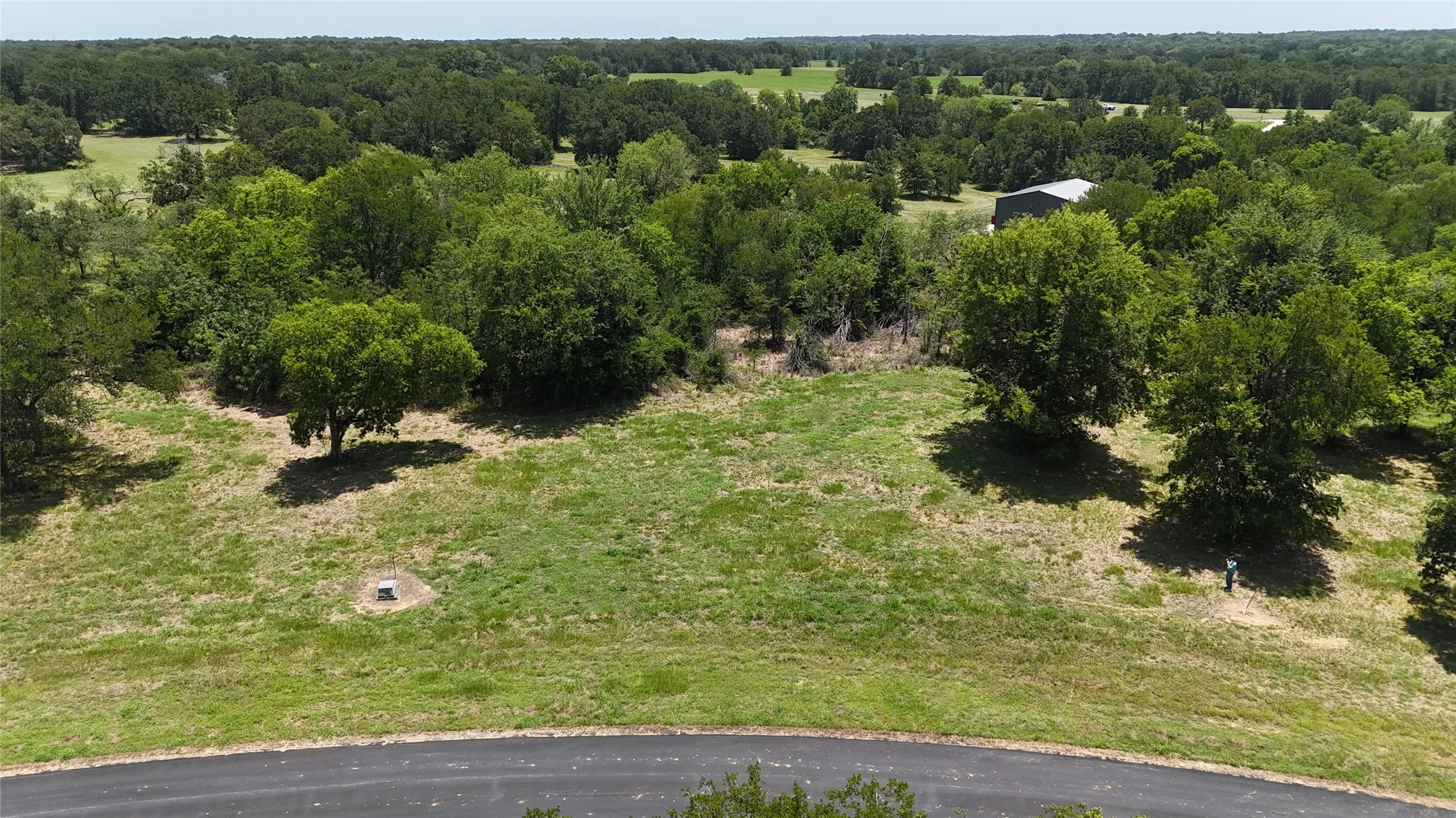Bird's-eye view of Lot 118 featuring a ideal mix of mature shade trees and cleared building space.