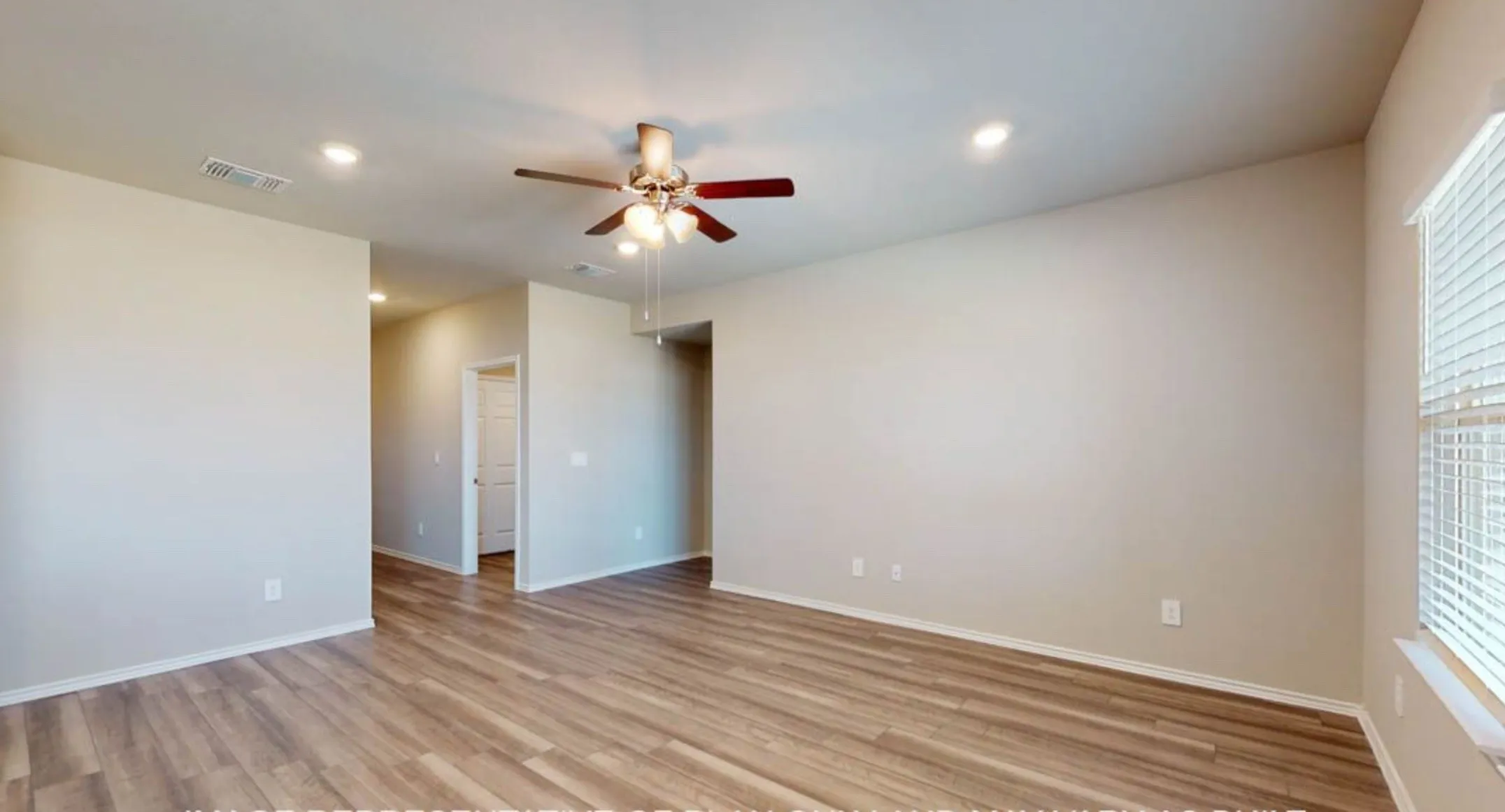 Spacious room with wood-finish flooring, light neutral wall paint, white trim, a ceiling fan, and recessed lighting