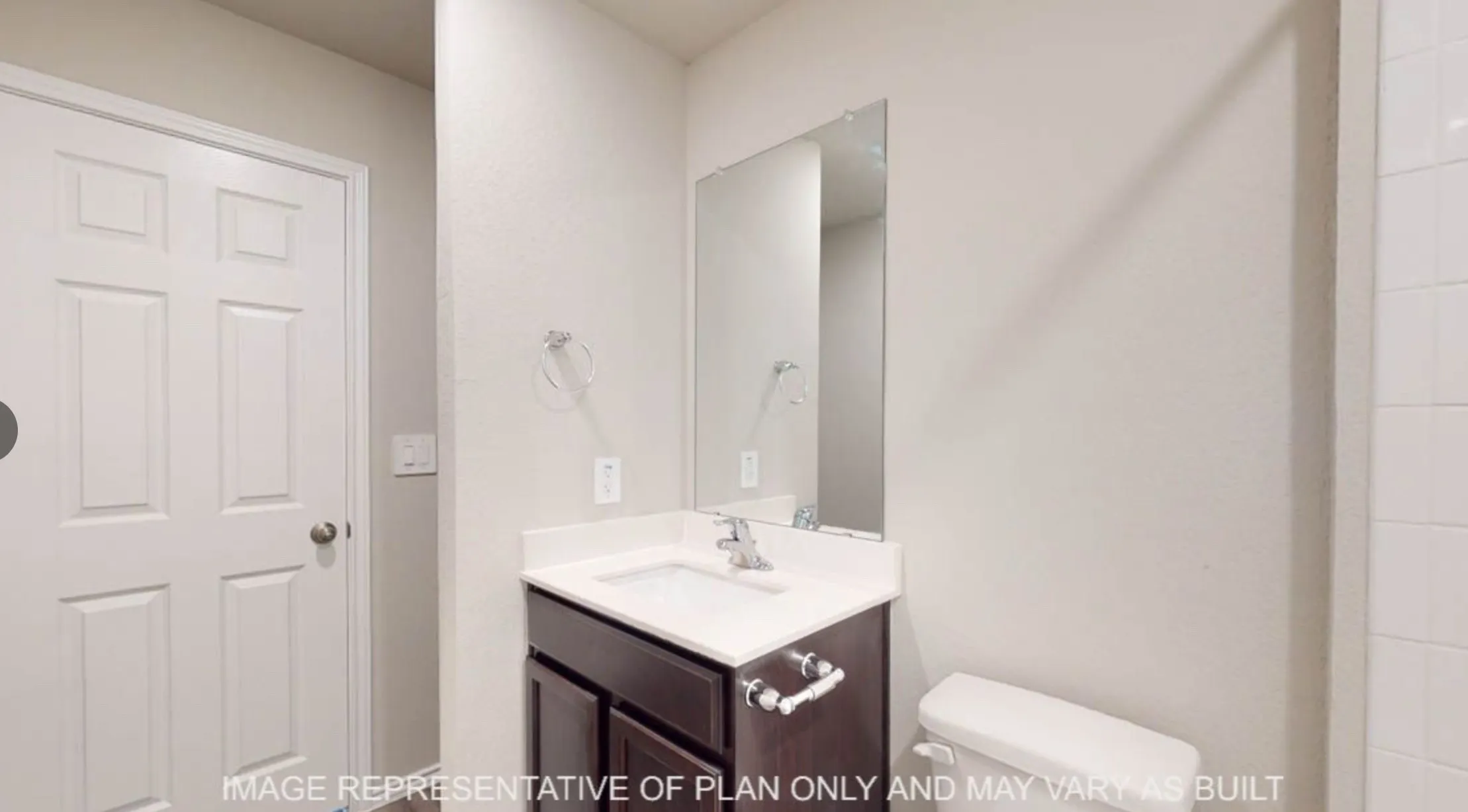 Bathroom featuring a dark wood-finish vanity with a white countertop and integrated sink