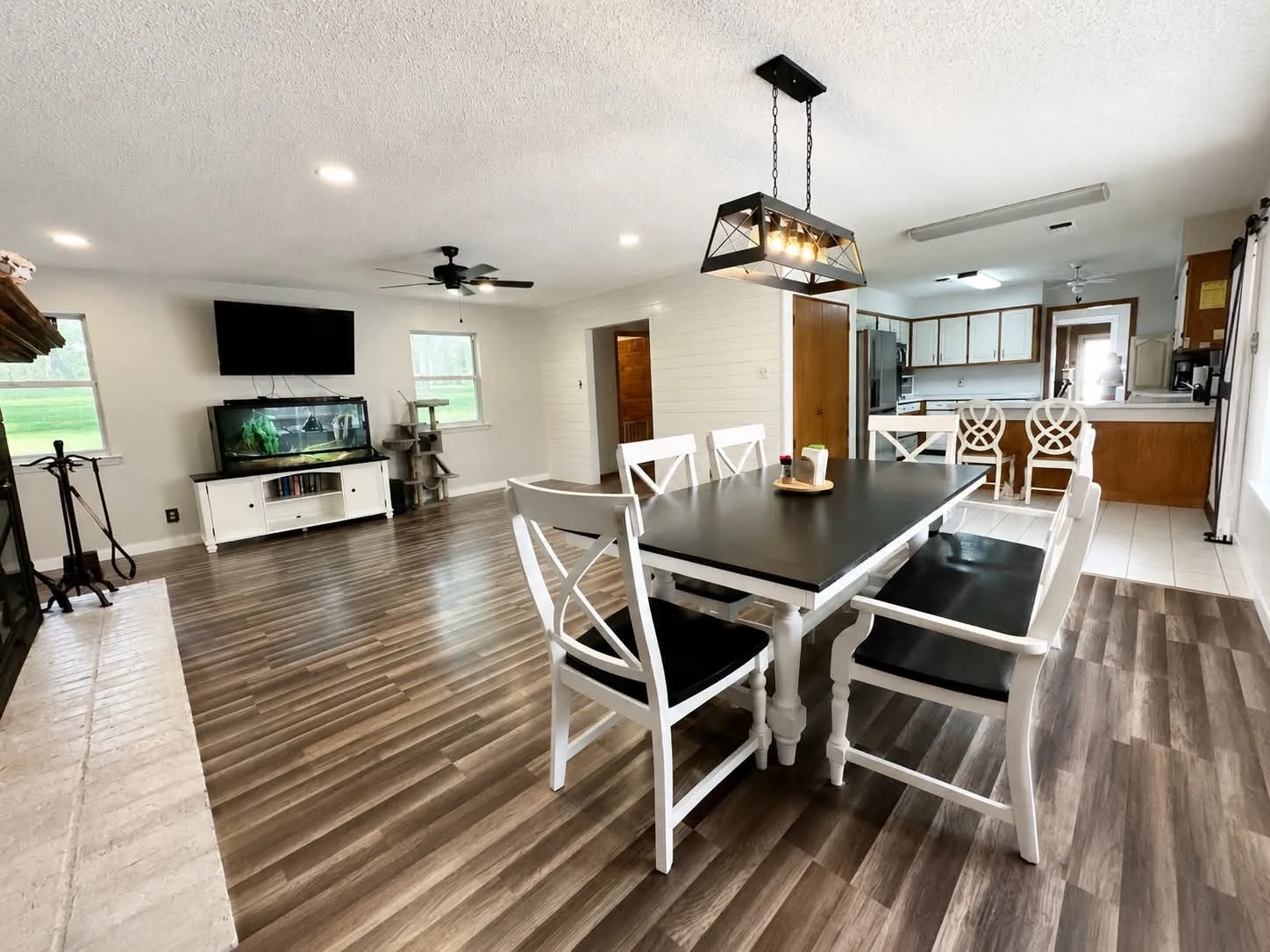 Open-concept dining area featuring a linear chandelier and wood-finish flooring