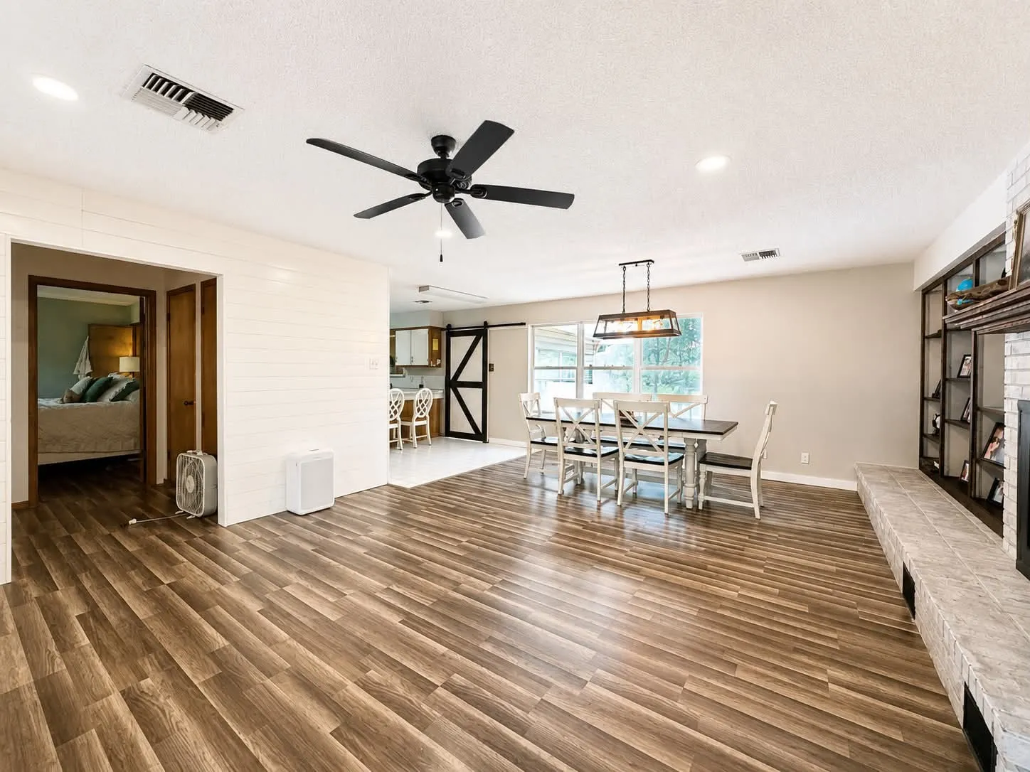 Open-concept living area featuring wood-finish flooring, a contemporary ceiling fan, and recessed lighting