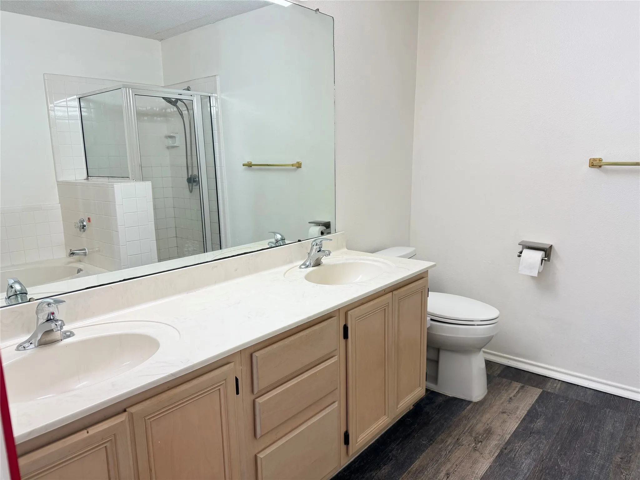 Bathroom featuring a double vanity with integrated sinks, light-toned cabinetry, and a large mirror