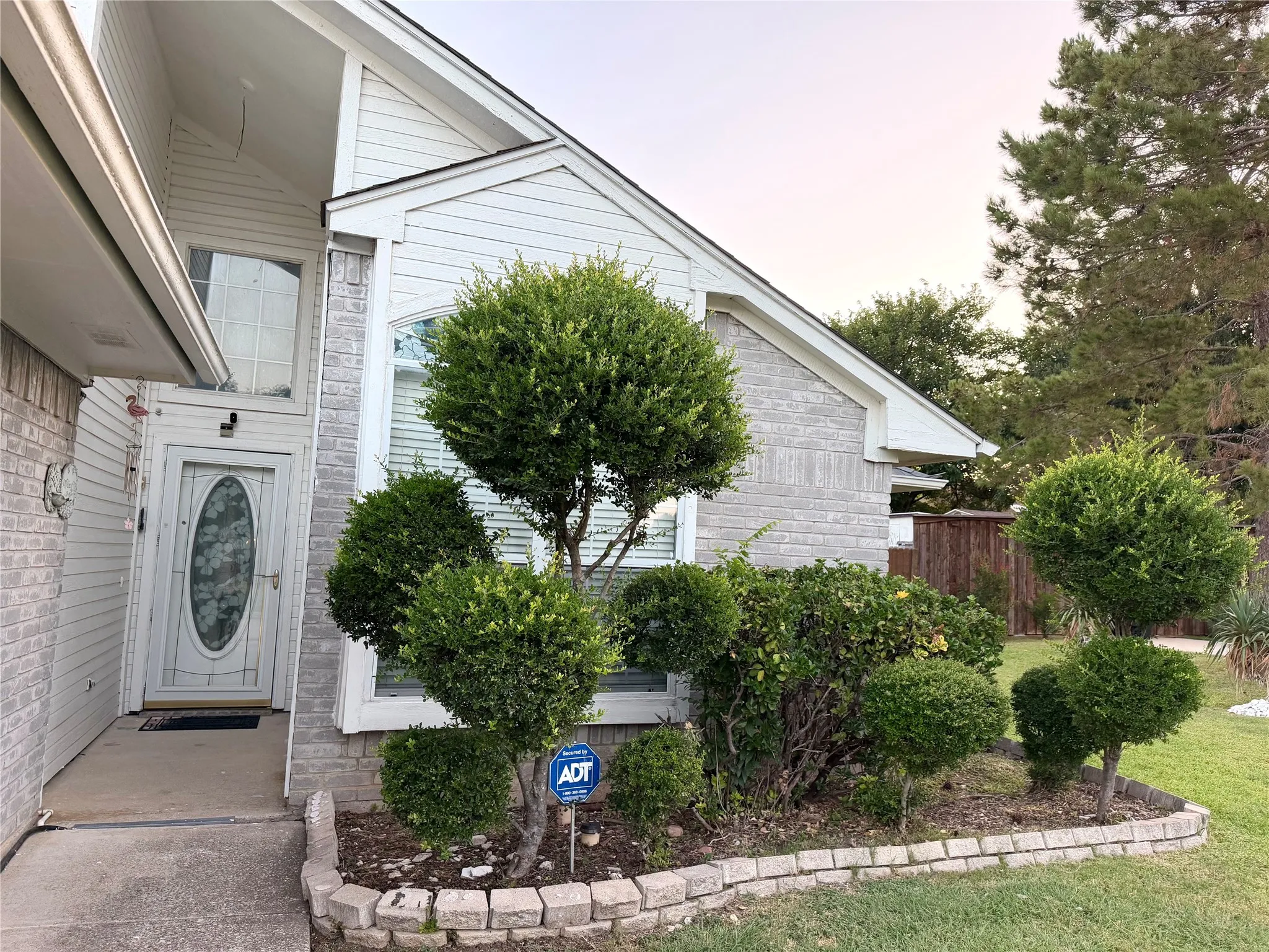 Front exterior featuring light gray brick veneer and horizontal siding accents