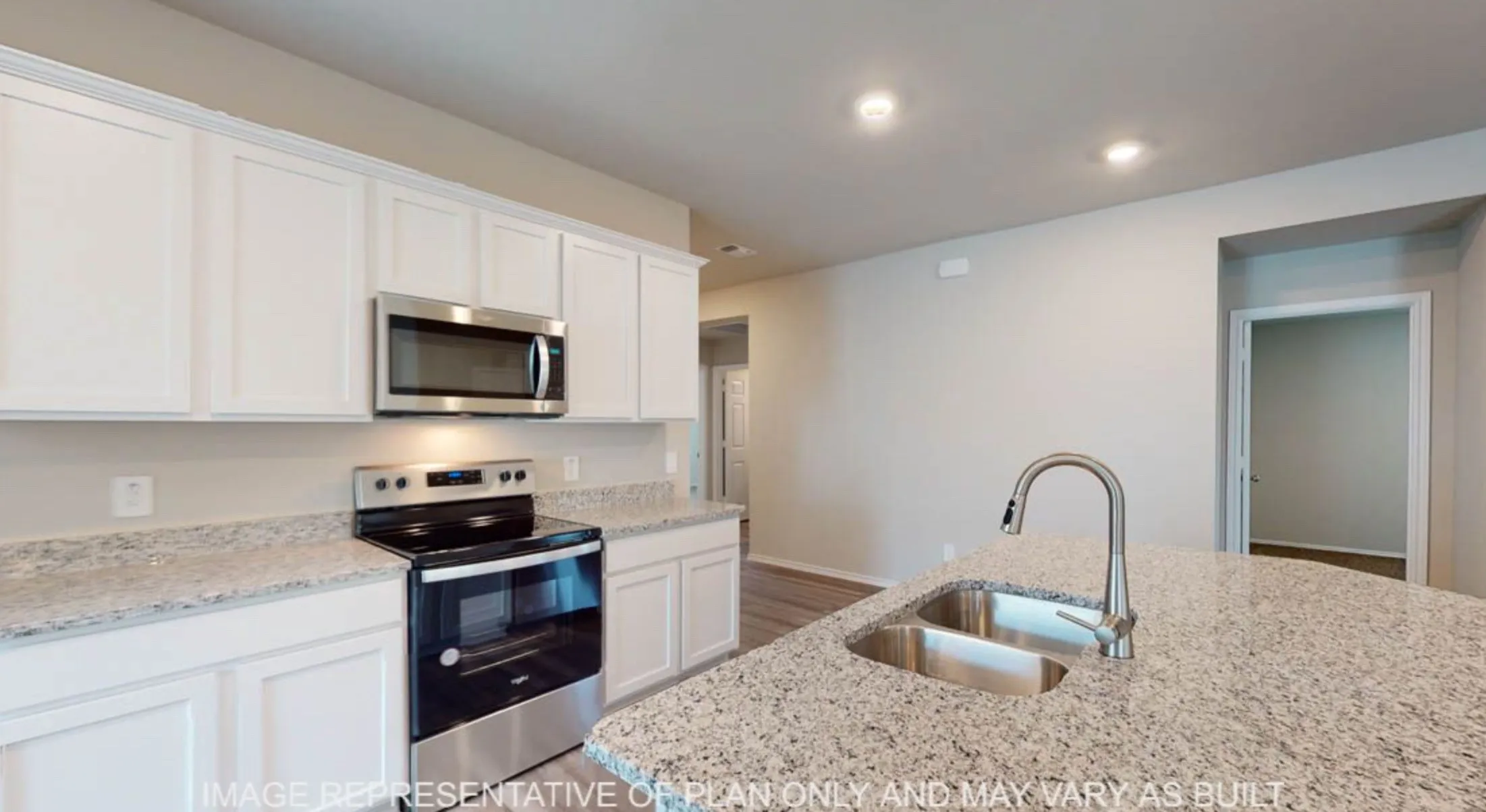 Kitchen featuring an island with a double basin stainless steel sink and a gooseneck faucet