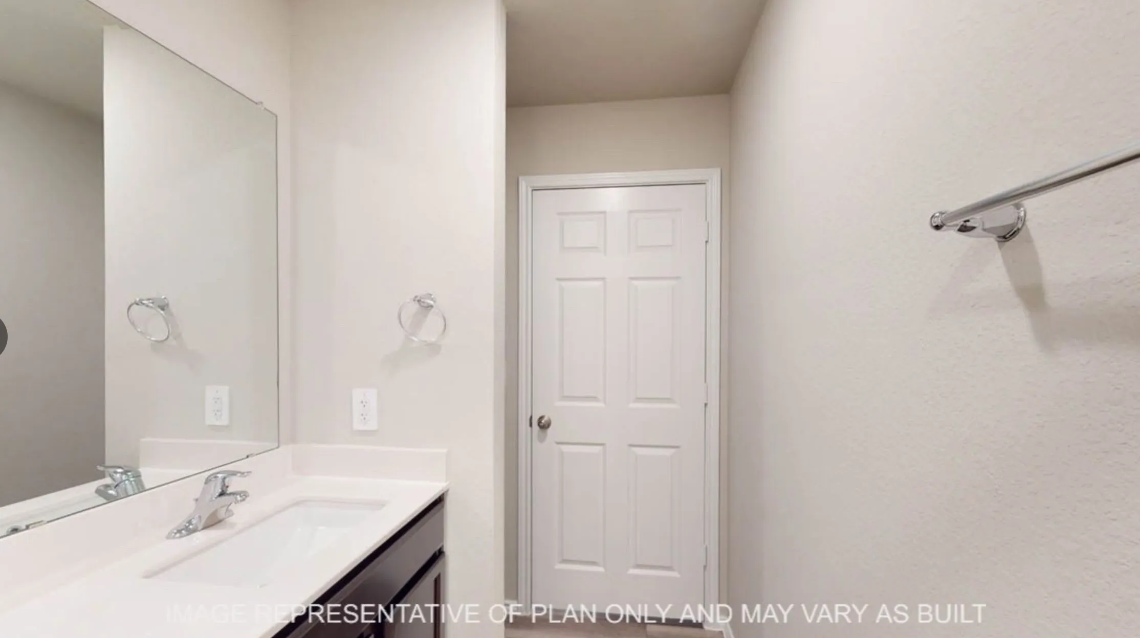Bathroom vanity featuring a rectangular under-mount sink, chrome faucet, and expansive wall-mounted mirror