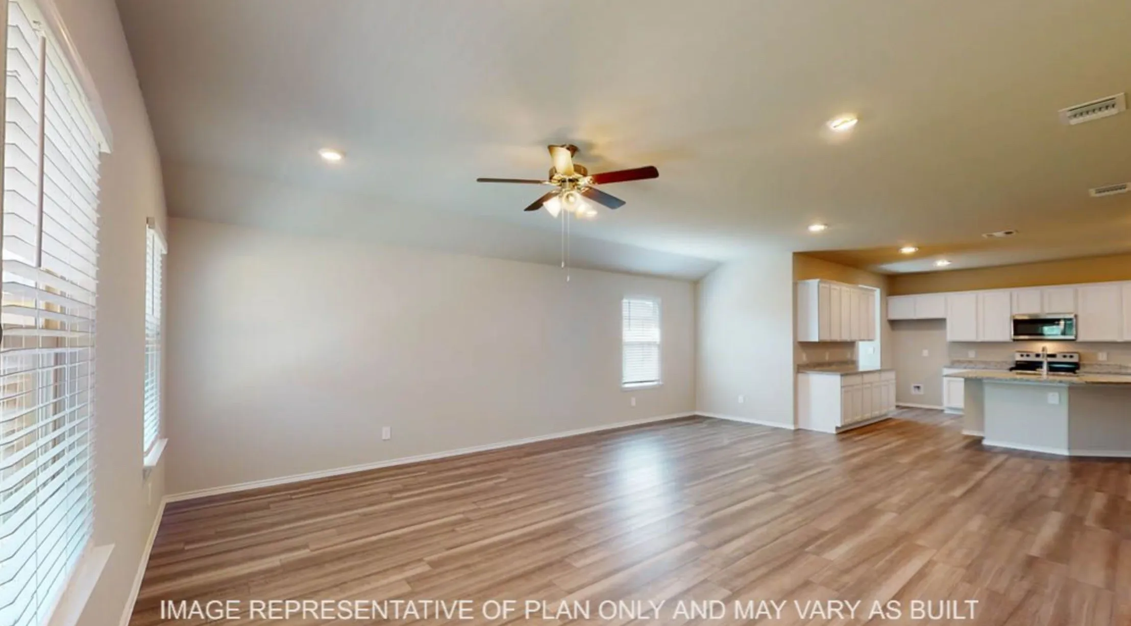 Open-concept living space featuring wood-finish flooring, vaulted ceilings, and recessed lighting