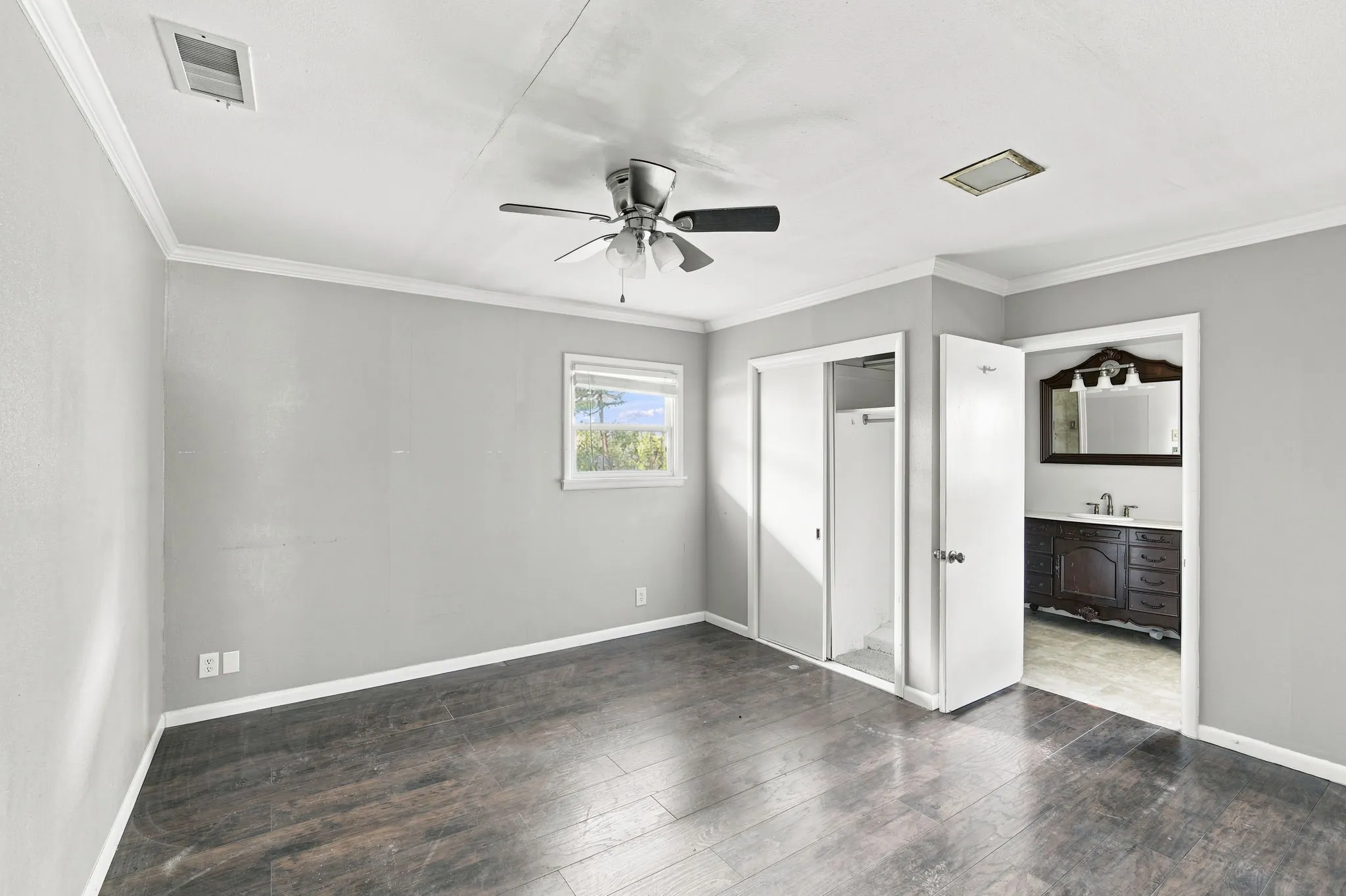 Bedroom featuring wood-finish flooring, light grey walls, white trim, and a ceiling fan