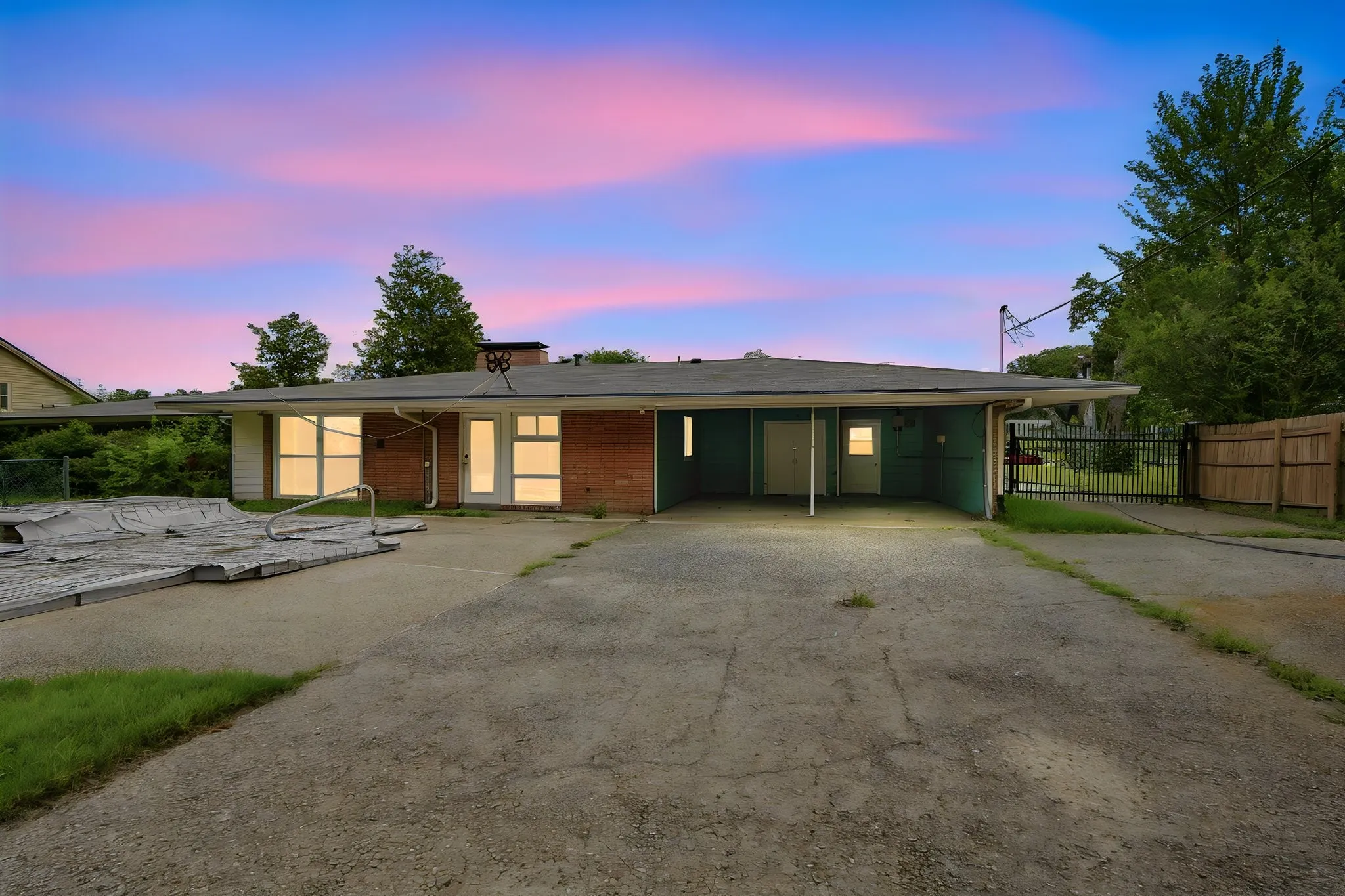 Ranch-style residence featuring a brick facade, covered carport, and a gated entry