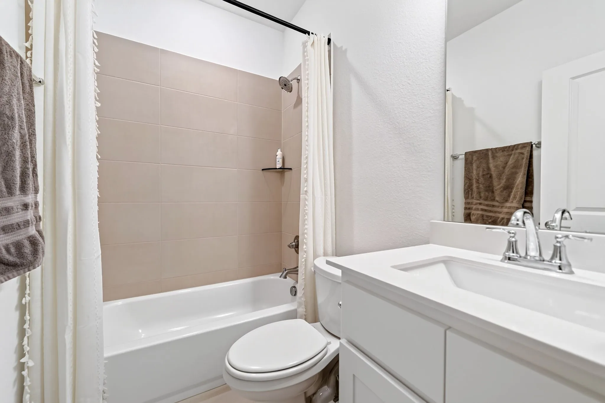 Bathroom featuring a white vanity with a white countertop, chrome faucet, a rectangular undermount sink, and an integrated mirror