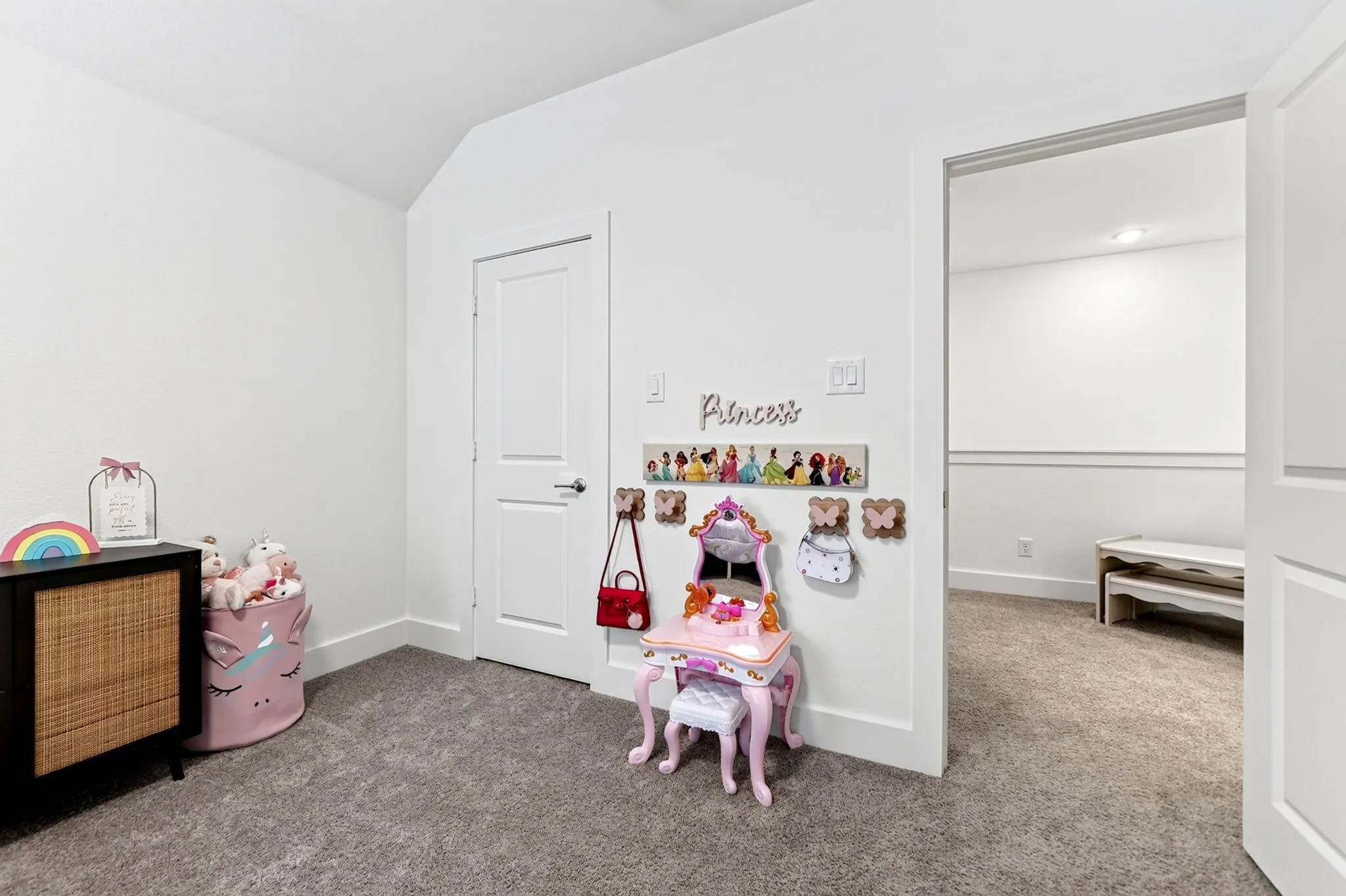 Carpeted room with white walls, baseboards, and door trim
