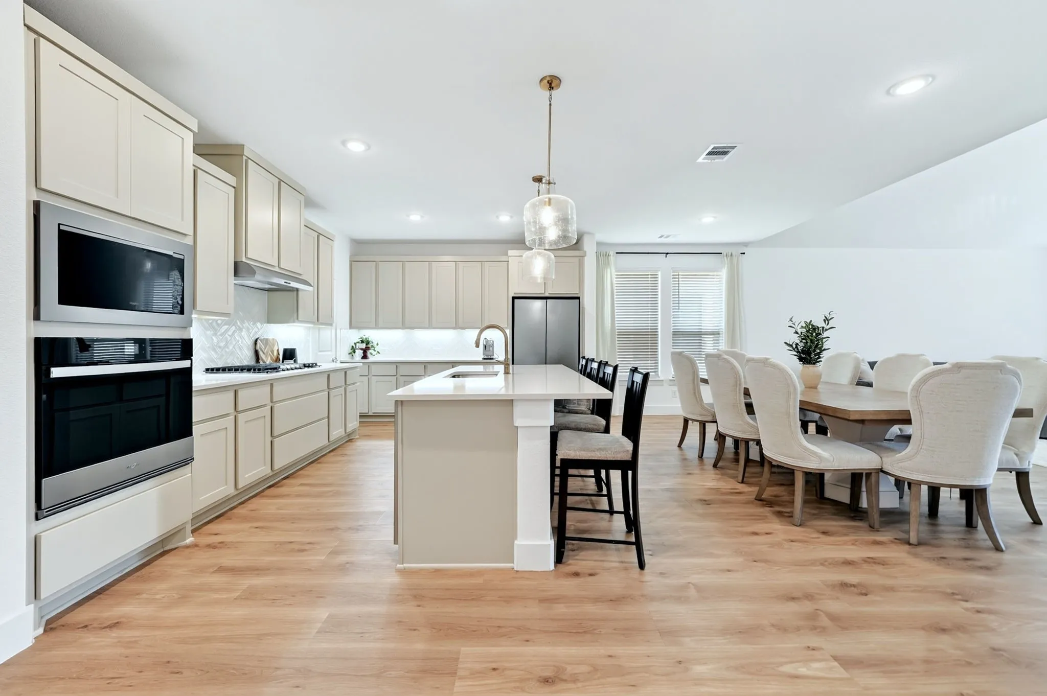 Open-concept kitchen and dining area featuring wood-finish flooring