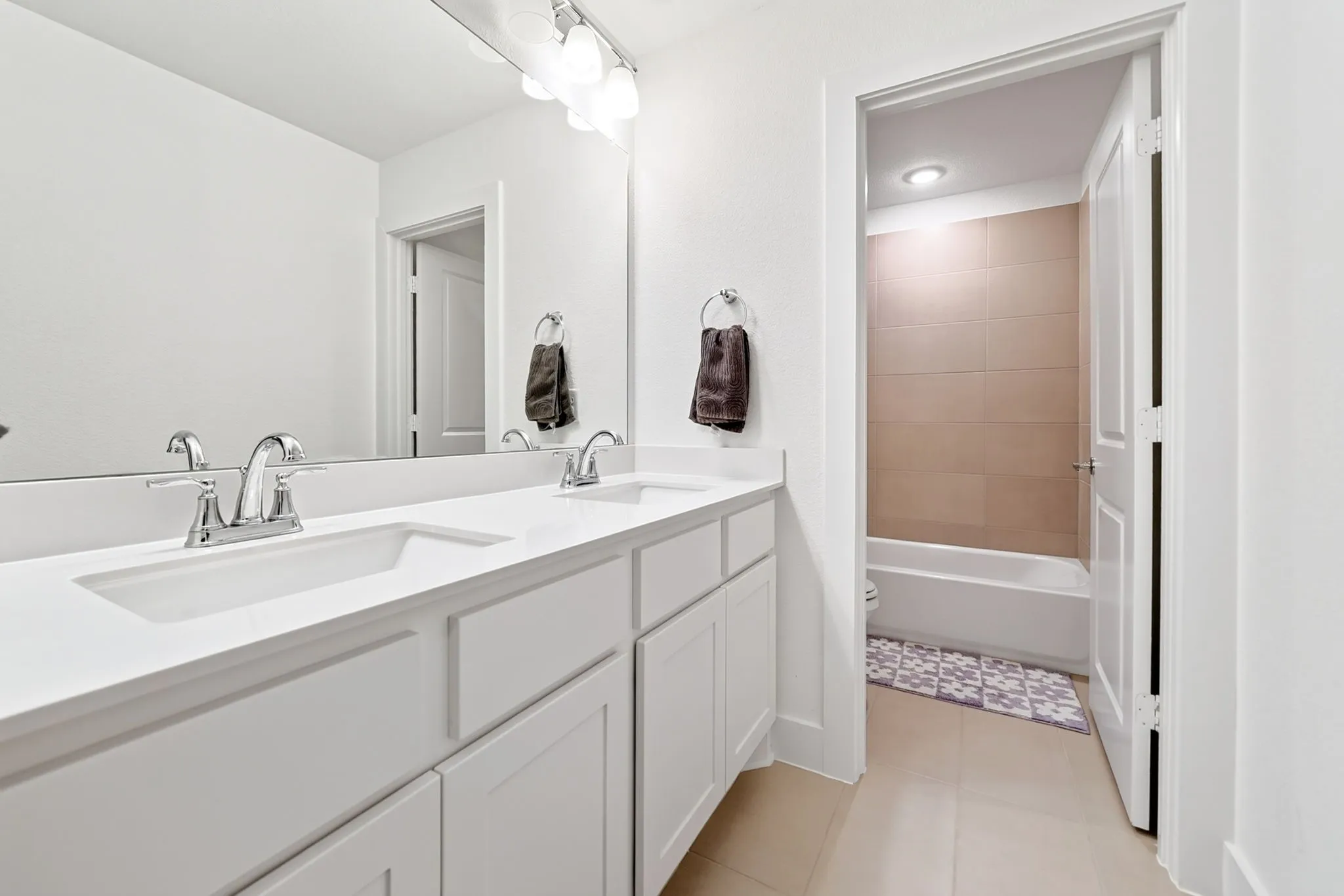 Dual sink vanity featuring white cabinetry, a white countertop, and chrome fixtures