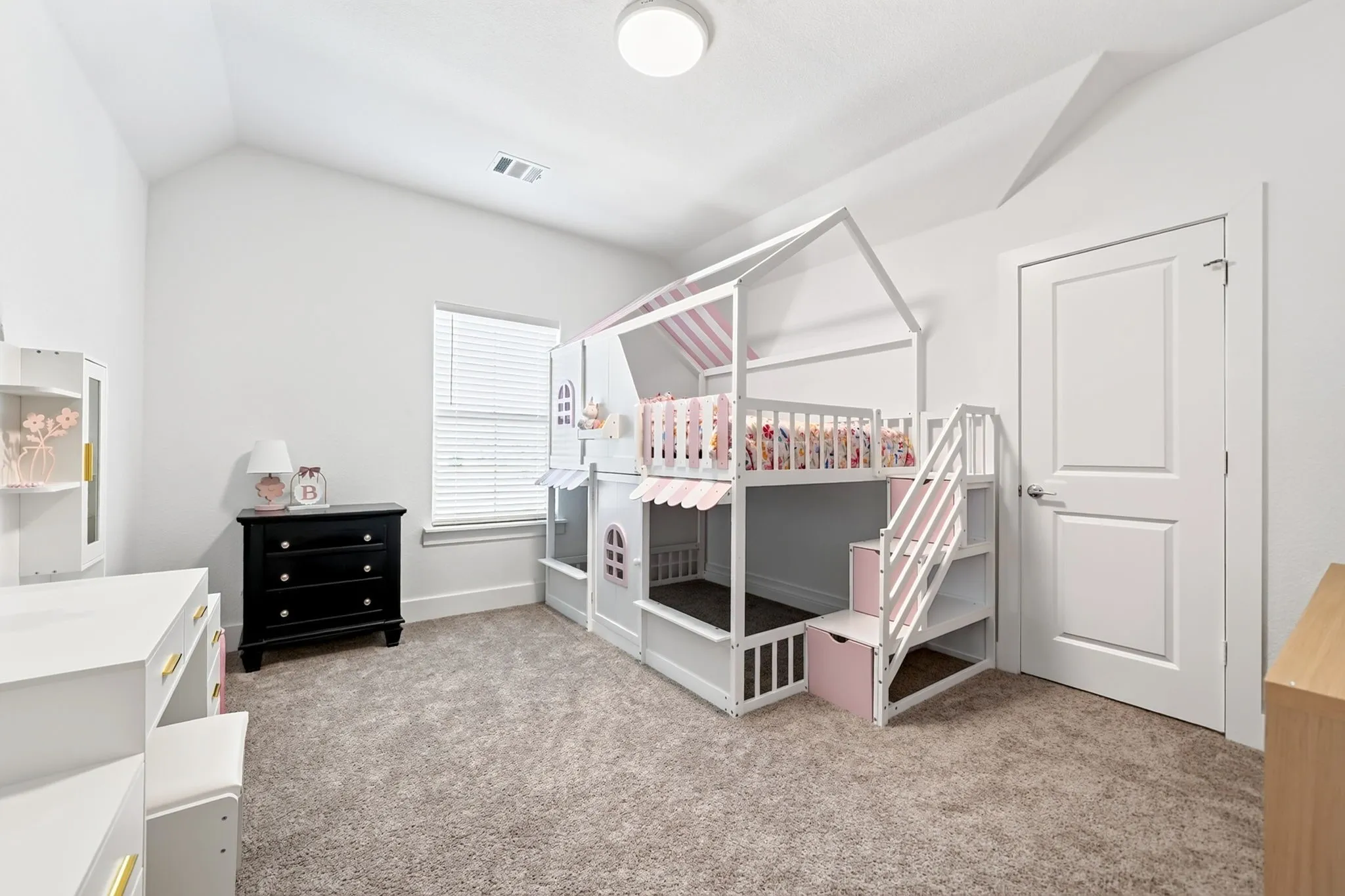 Room featuring a vaulted ceiling and neutral-toned carpet flooring
