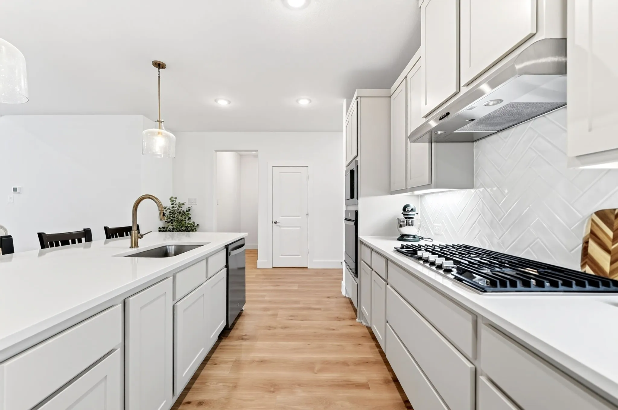 Modern kitchen featuring a spacious island with an undermount sink and gooseneck faucet