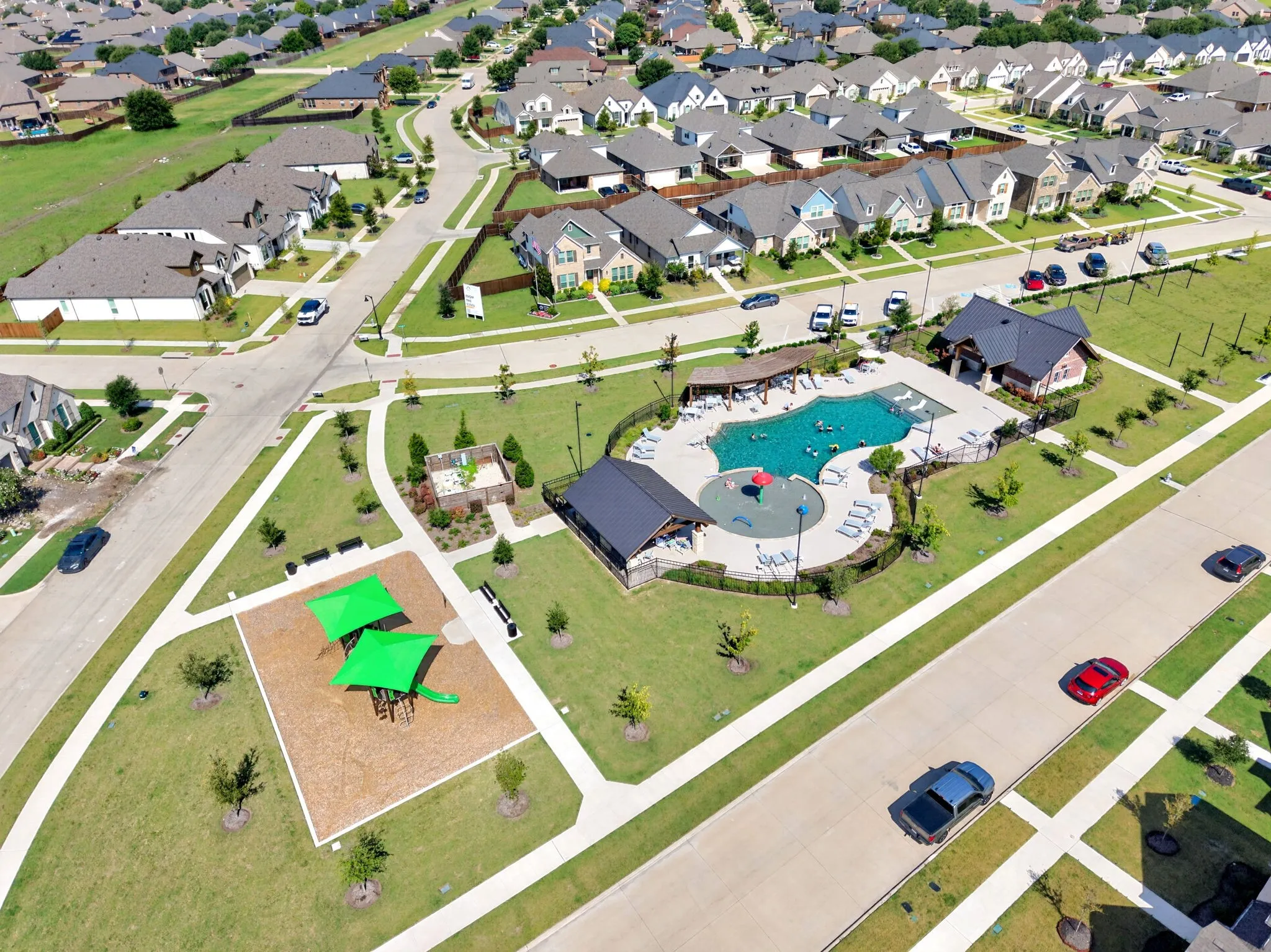 Community amenities featuring a swimming pool with surrounding lounge chairs, a covered pavilion, and a separate shaded playground area with ground cover