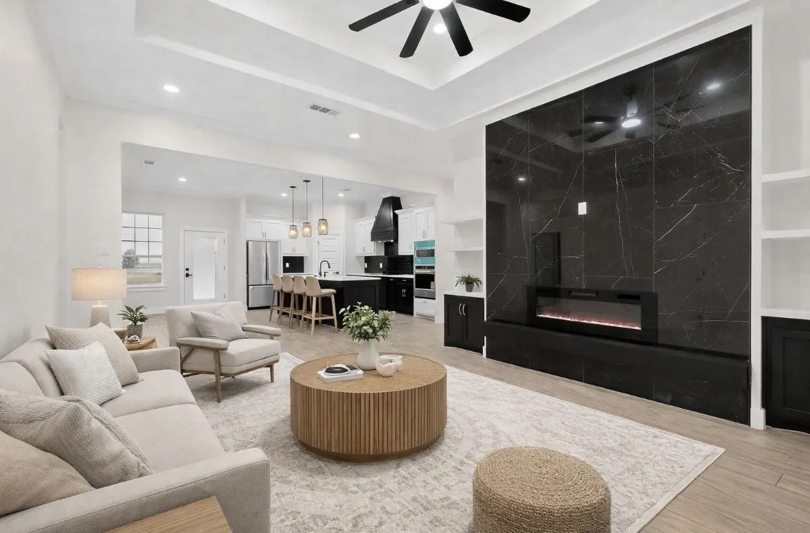 Spacious living area featuring a tray ceiling with recessed lighting and a ceiling fan