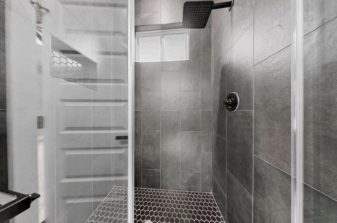 Modern shower enclosure featuring glass panels and matte black hardware