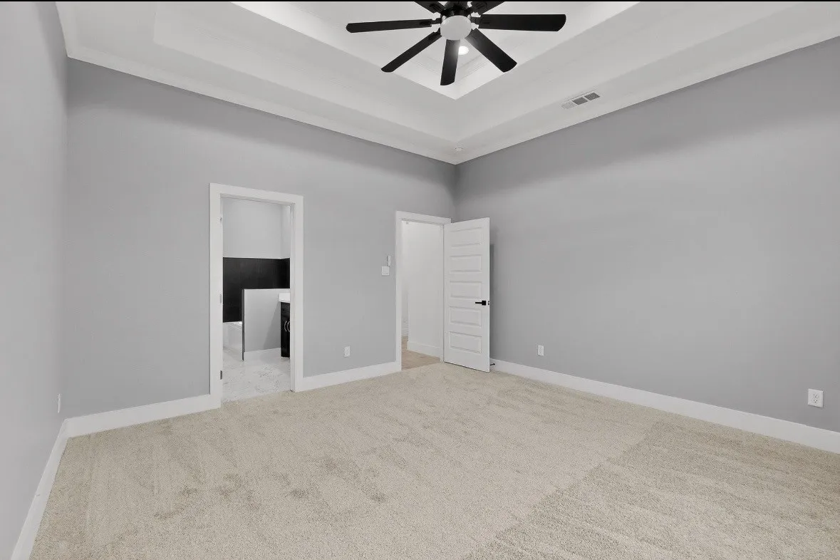 Spacious room featuring light gray walls and plush neutral carpeting