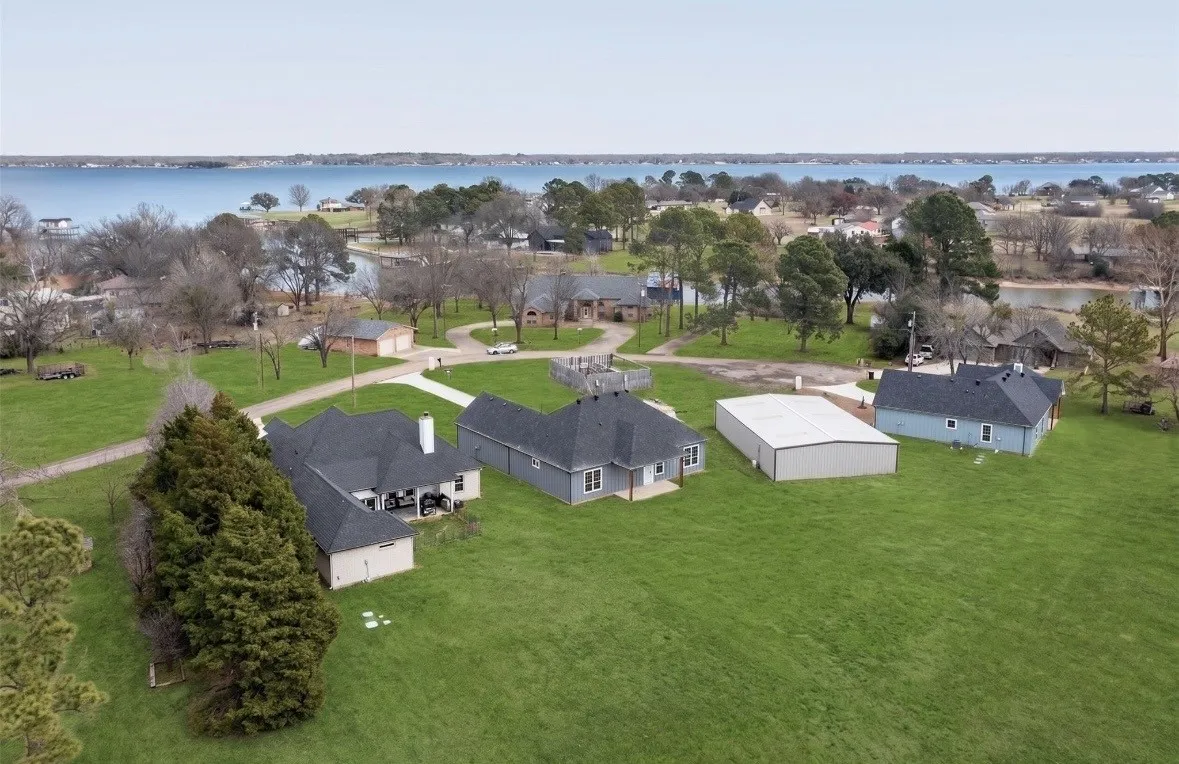 Expansive green property featuring multiple residential structures and a large metal outbuilding
