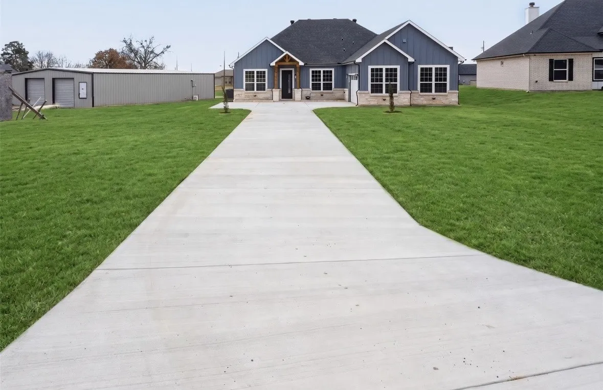 Modern farmhouse exterior with blue siding and stone veneer accents