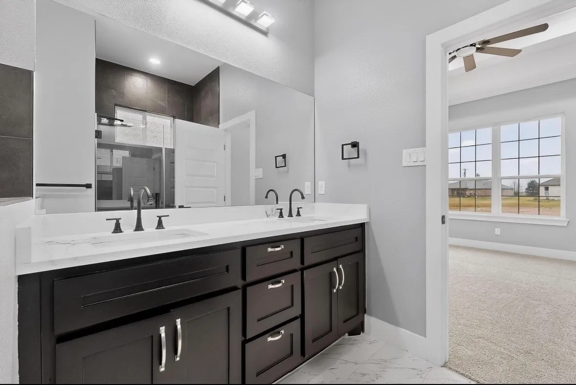 Bathroom featuring a dual vanity with dark wood cabinetry, white countertops, and undermount sinks