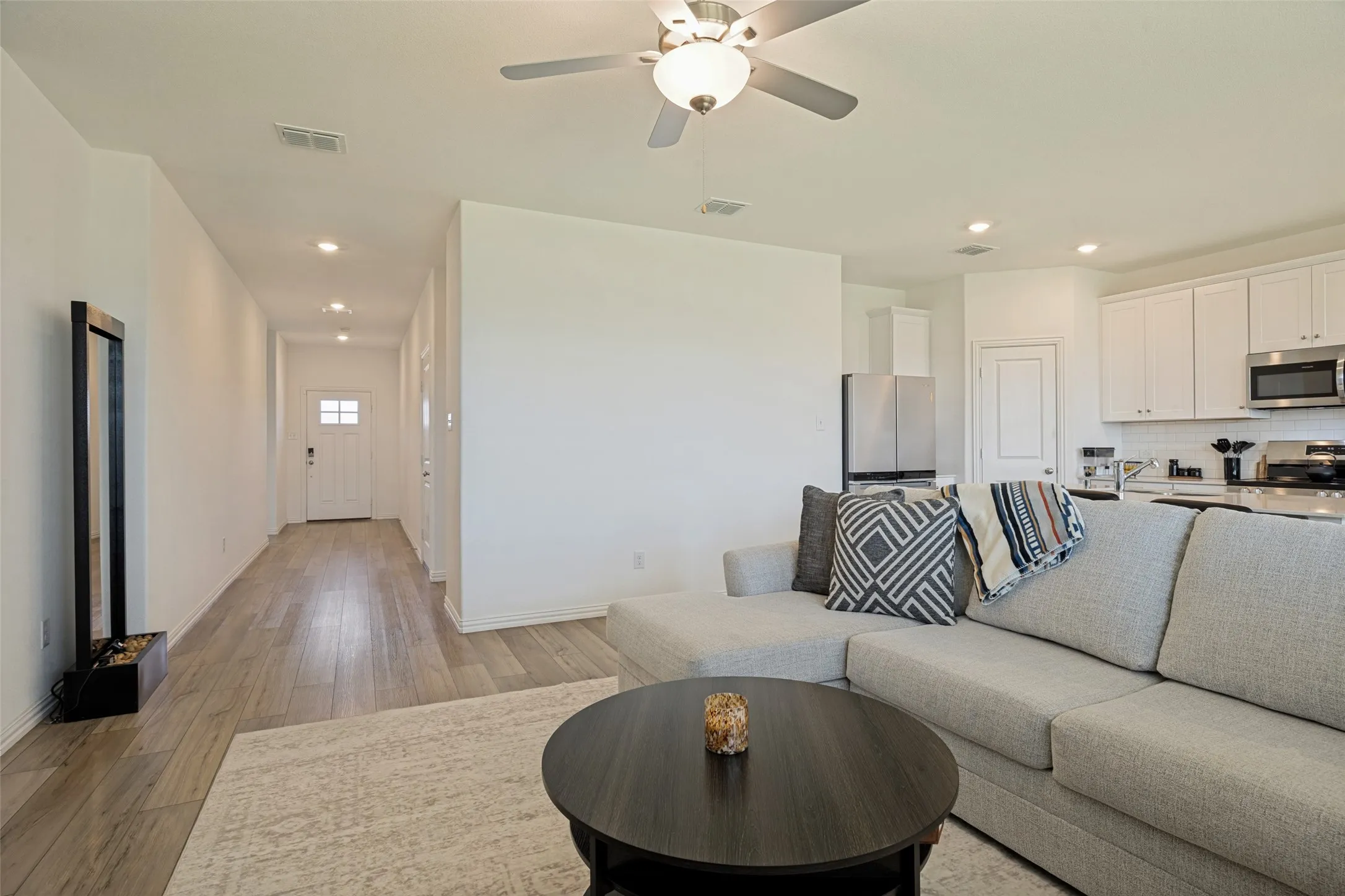 Open-concept living space featuring wood-finish flooring, recessed lighting, and a ceiling fan