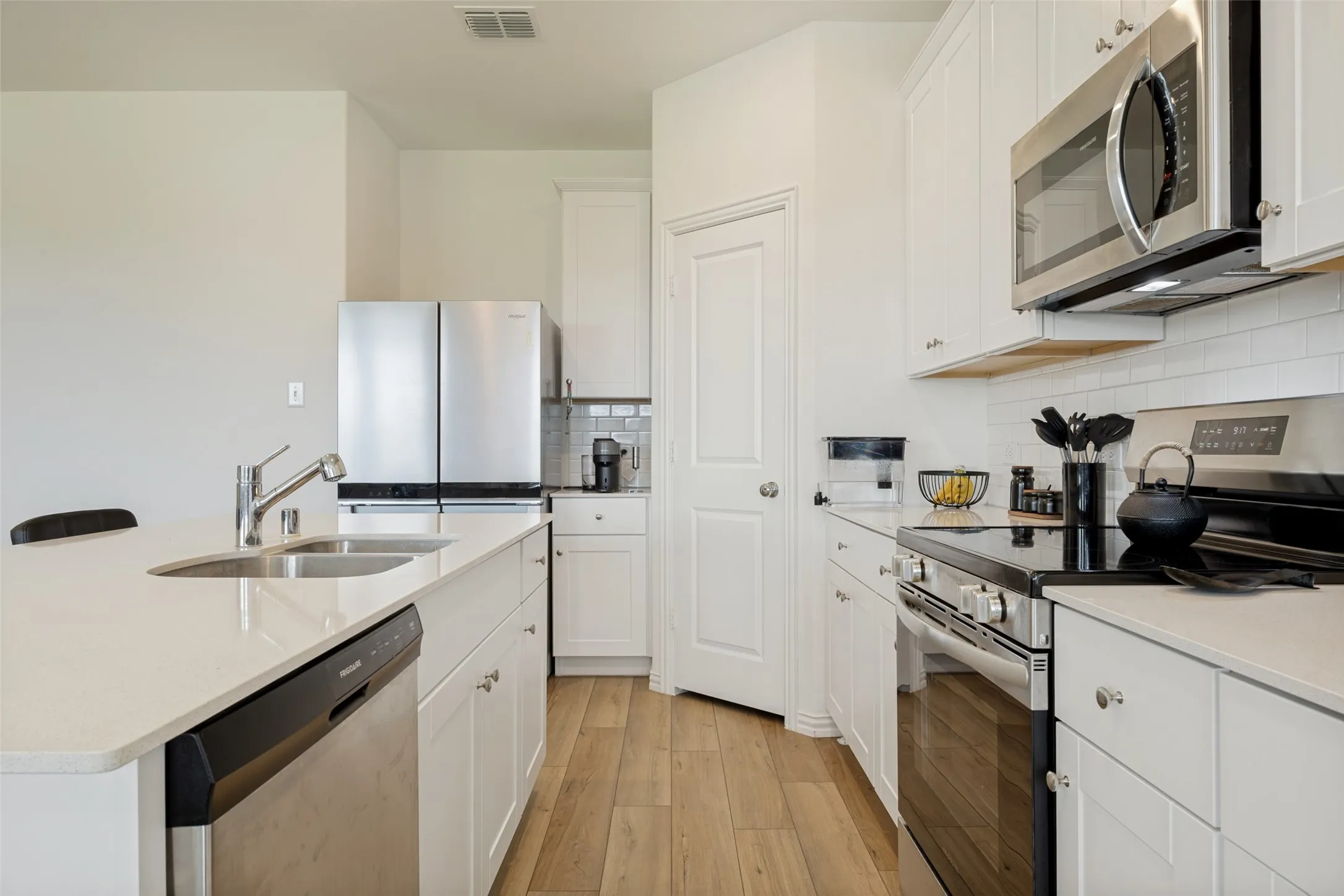 Modern kitchen featuring an island with an undermount sink and stainless steel dishwasher
