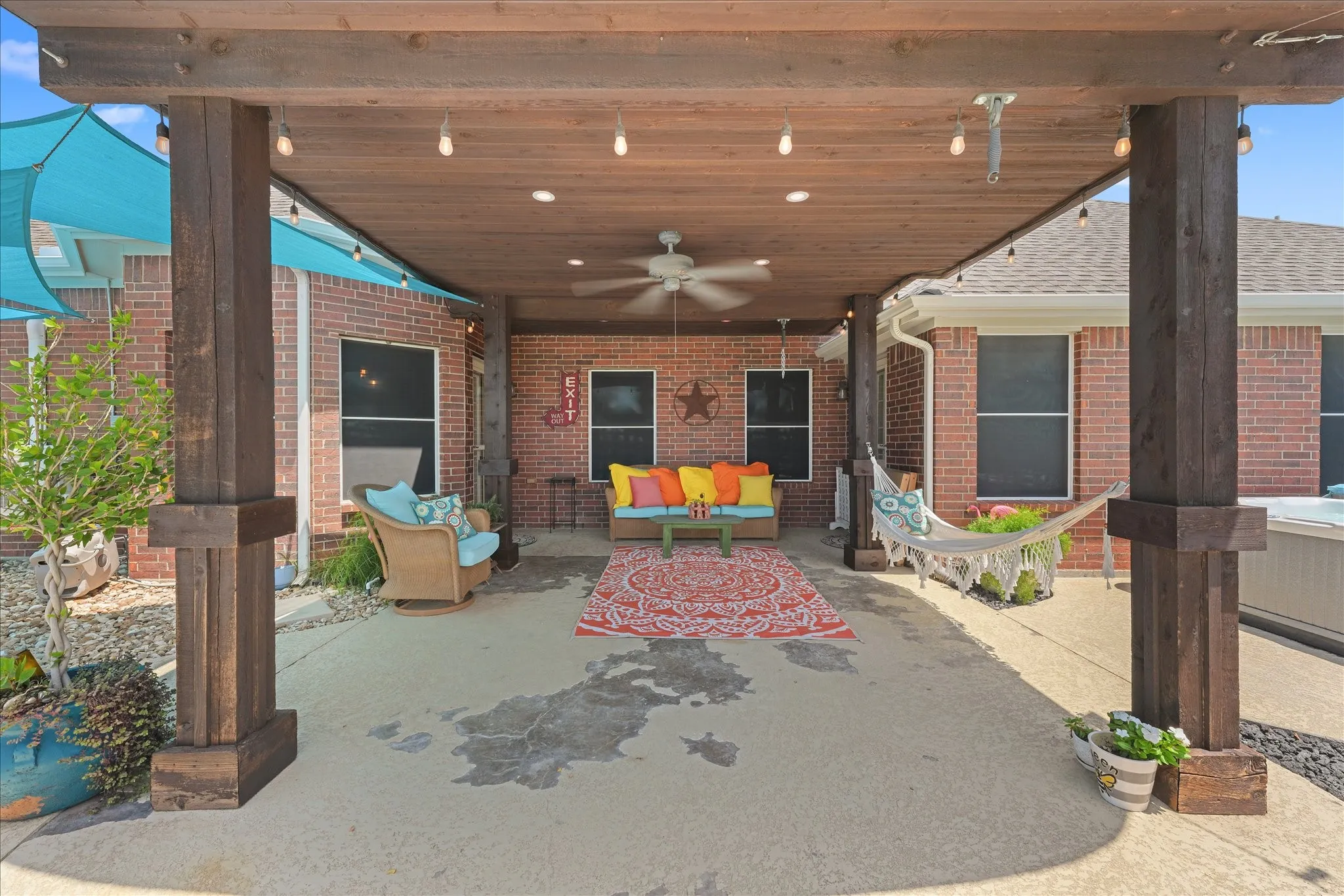 Covered patio featuring a wood-finish ceiling, integrated recessed lighting, string lights, and a ceiling fan