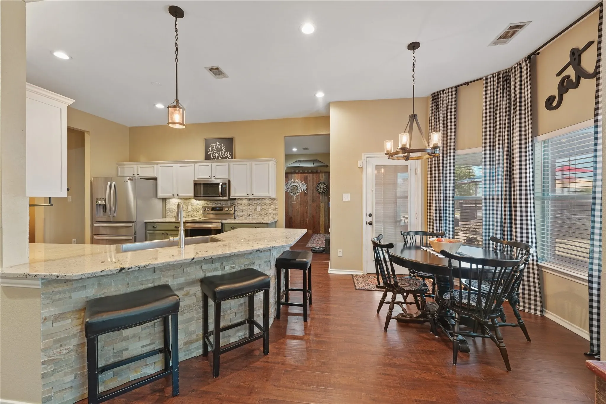 Open-concept kitchen and breakfast area featuring wood-finish flooring